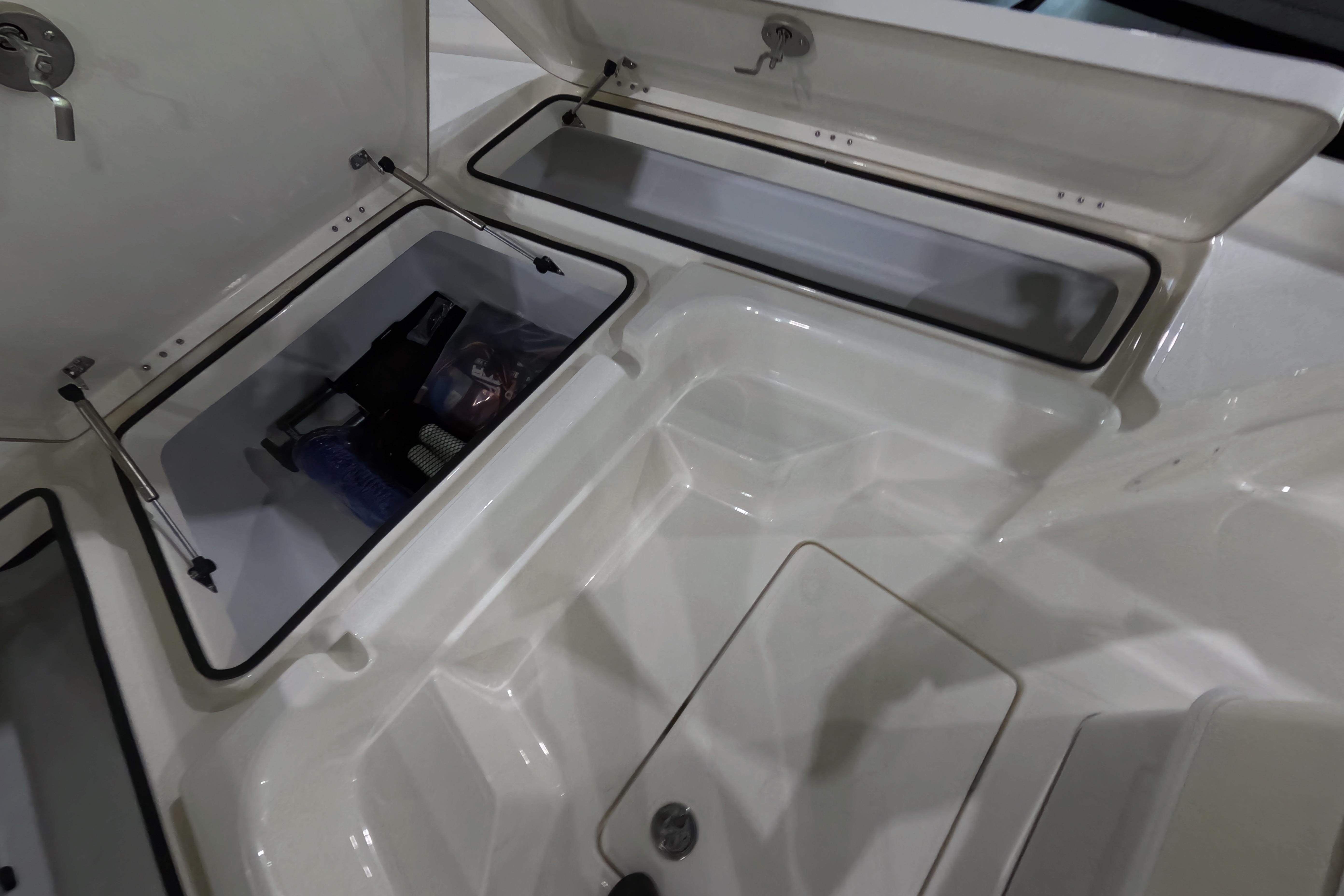 2026 Skeeter SX221 boat storage compartments with open lids, showcasing interior space.