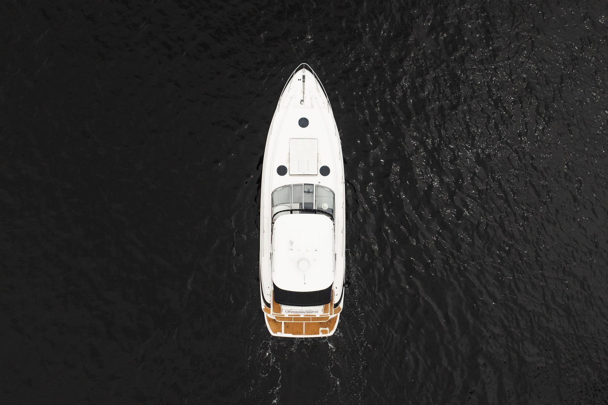 Aerial view of 2008 Regal Commodore 4460 yacht on dark water.