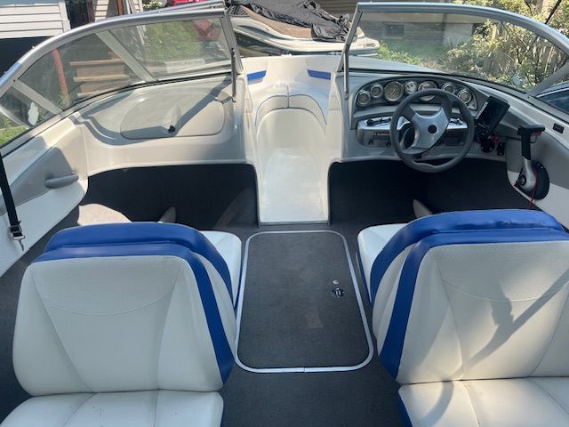 Interior of a Bayliner 185 boat with blue and white seats.