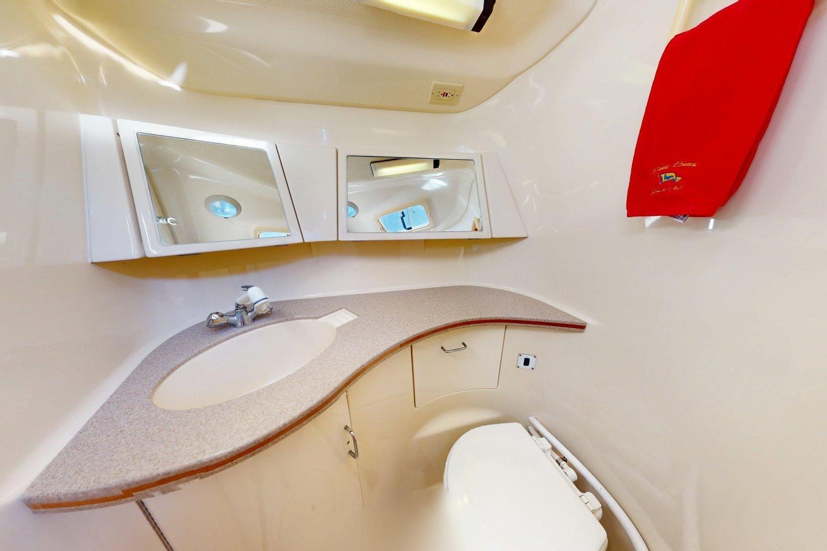 Bathroom interior of 1997 Hunter Legend 40.5 yacht with sink, mirror, and red towel.