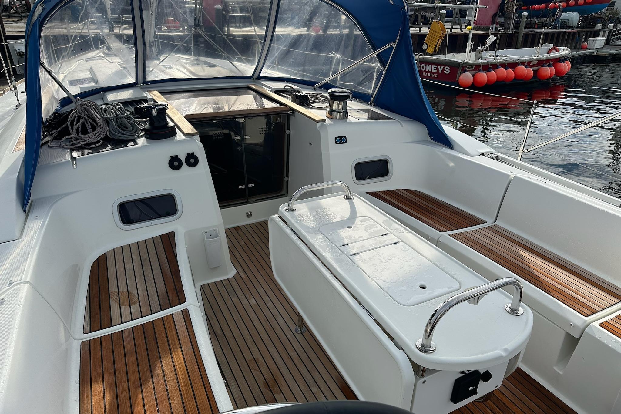 2018 Jeanneau Sun Odyssey 479 sailboat cockpit with teak flooring and blue canopy.