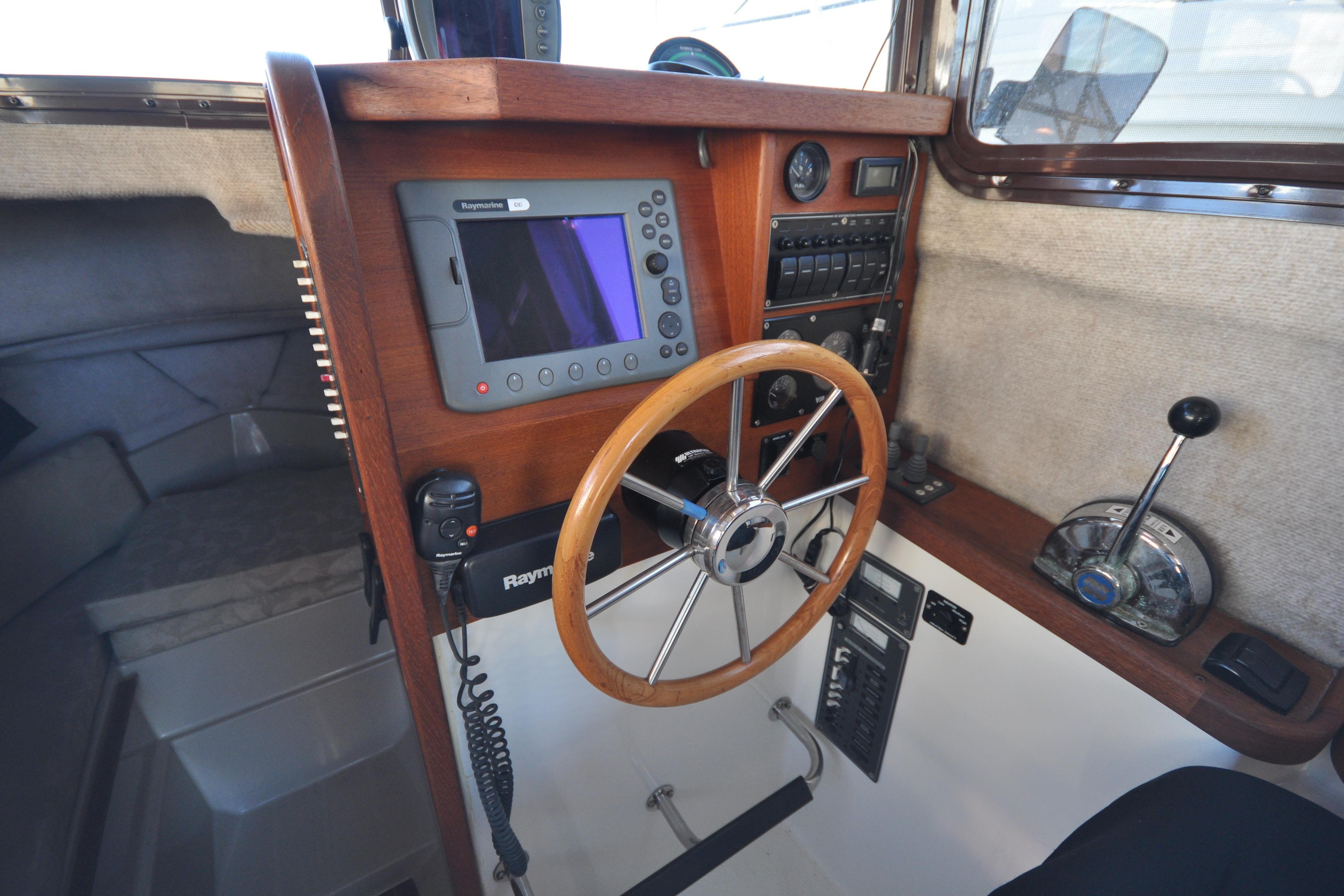 Interior helm of 2007 Ranger Tug R-25 with steering wheel and navigation equipment.
