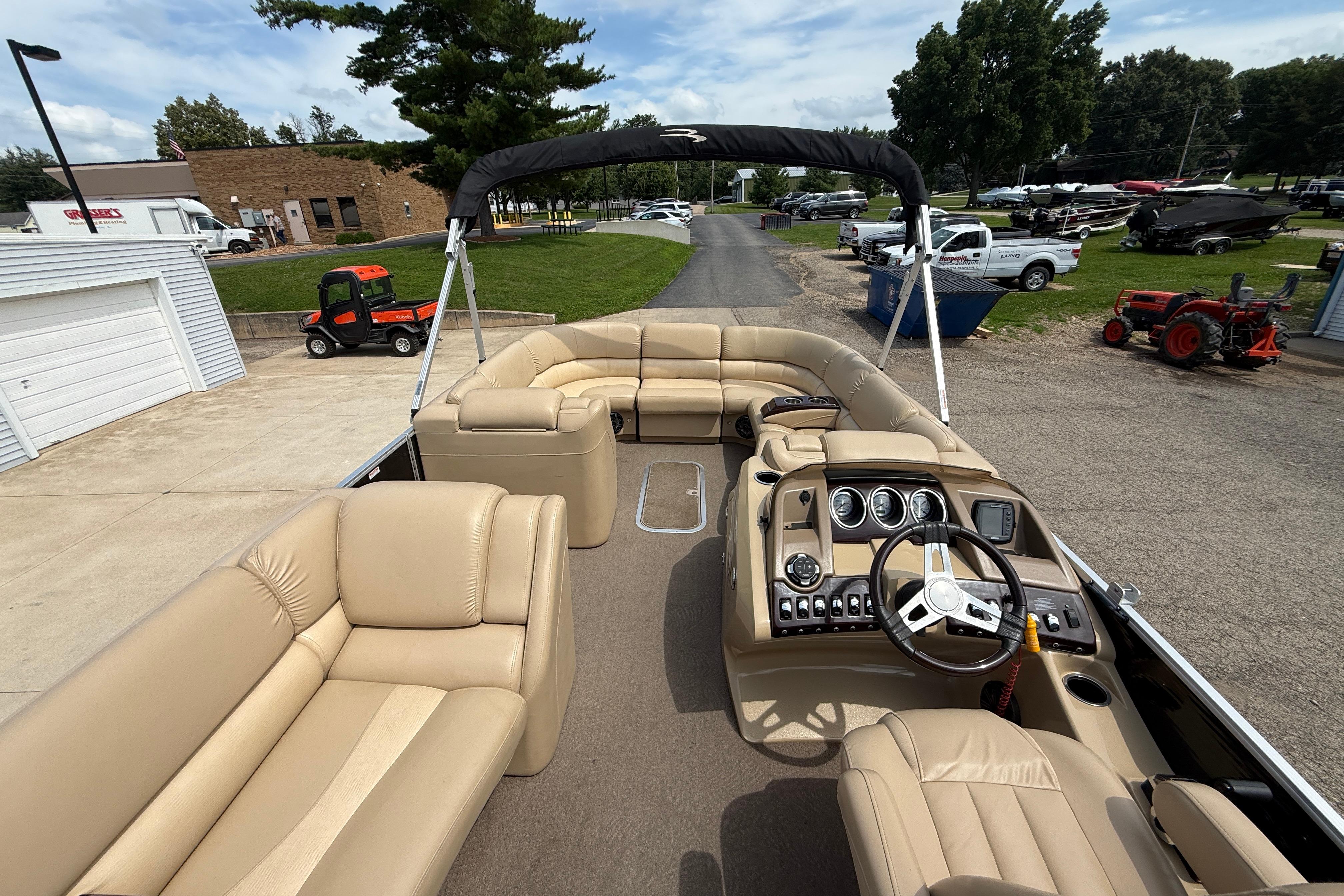 2011 Bennington 2575QCW I/O pontoon boat with beige seating and steering console.