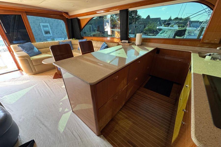Luxurious interior of 2002 Viking 61 Enclosed Bridge yacht with spacious seating and modern kitchen.