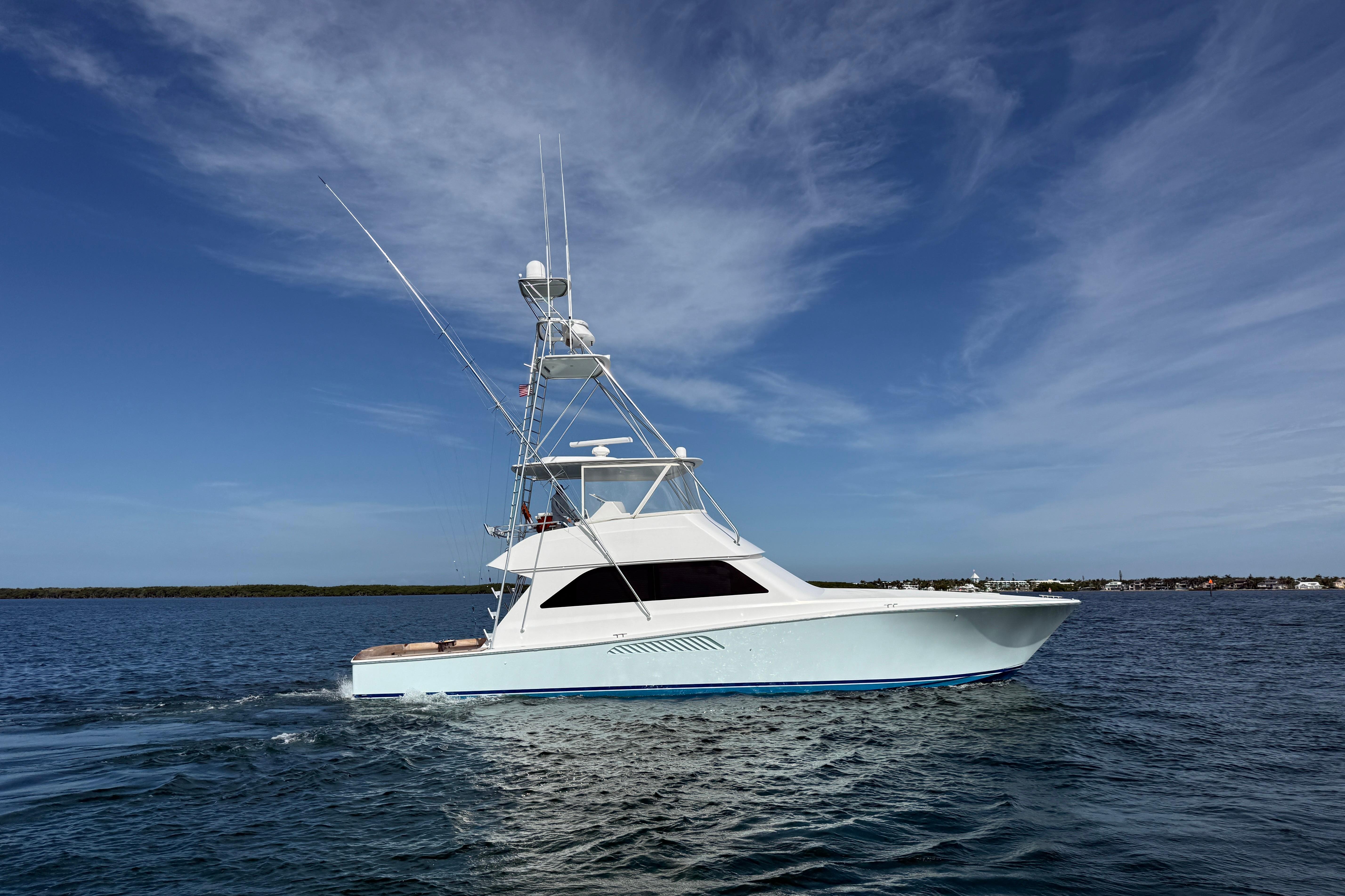 2000 Viking 55 Convertible yacht cruising on open water under a clear blue sky.
