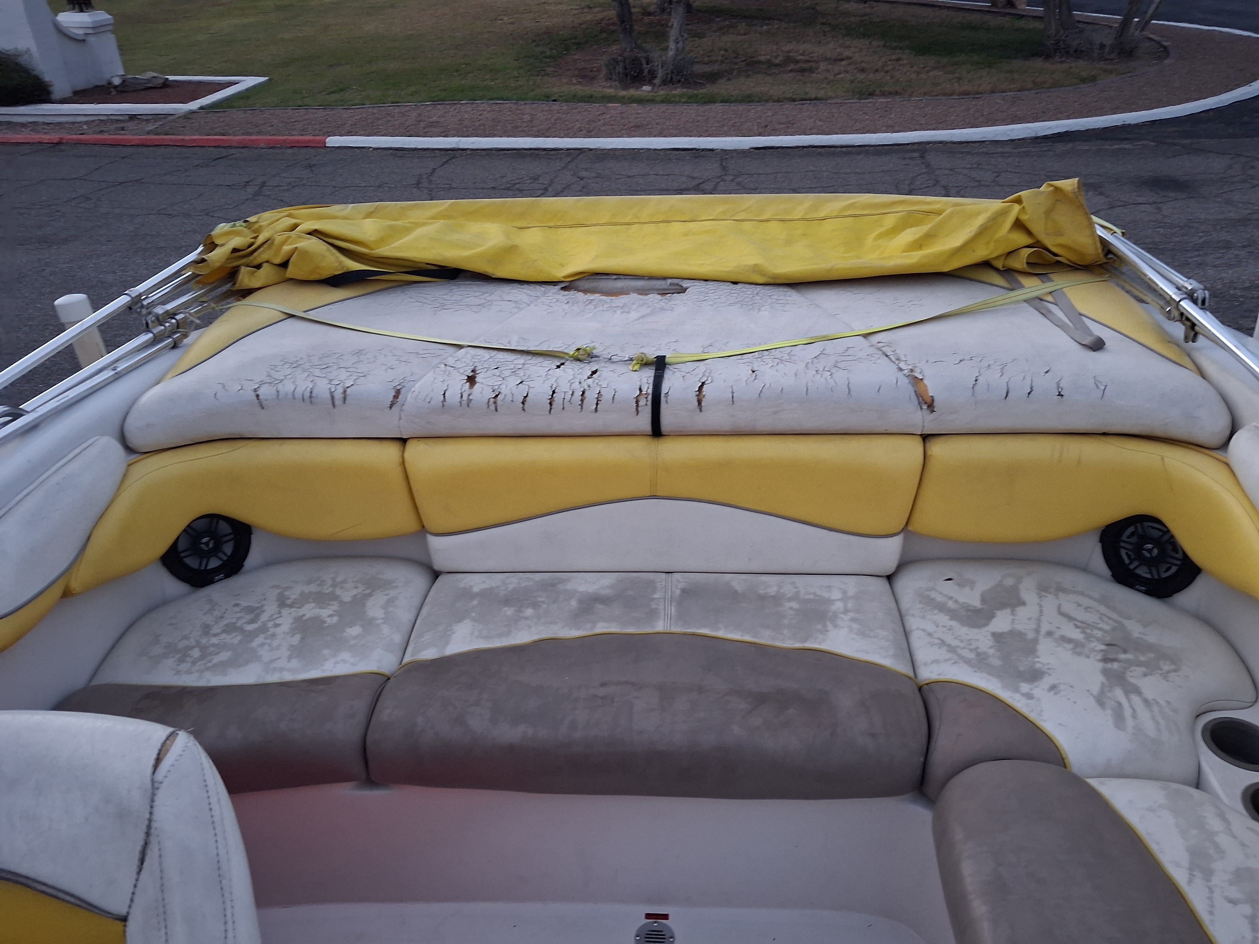 2004 Tracker Tahoe boat with worn yellow and white seats.