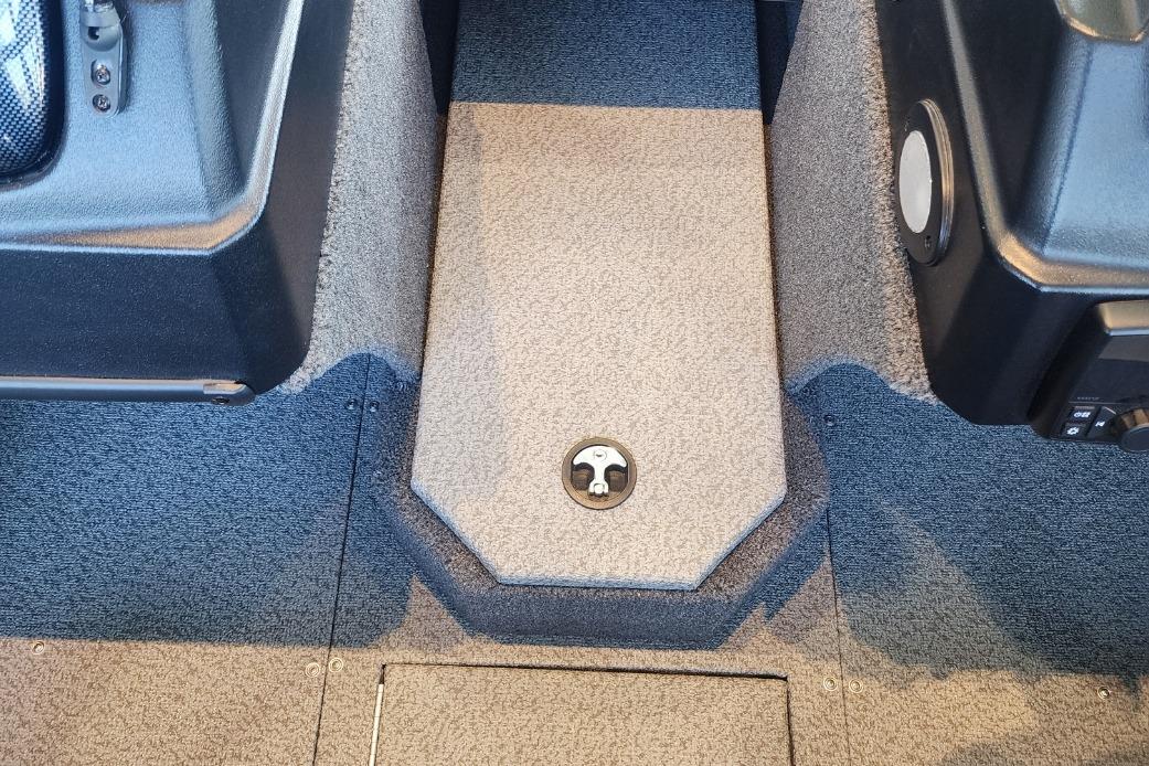 Interior of a 2023 Lowe boat, featuring carpeted flooring and storage compartments.