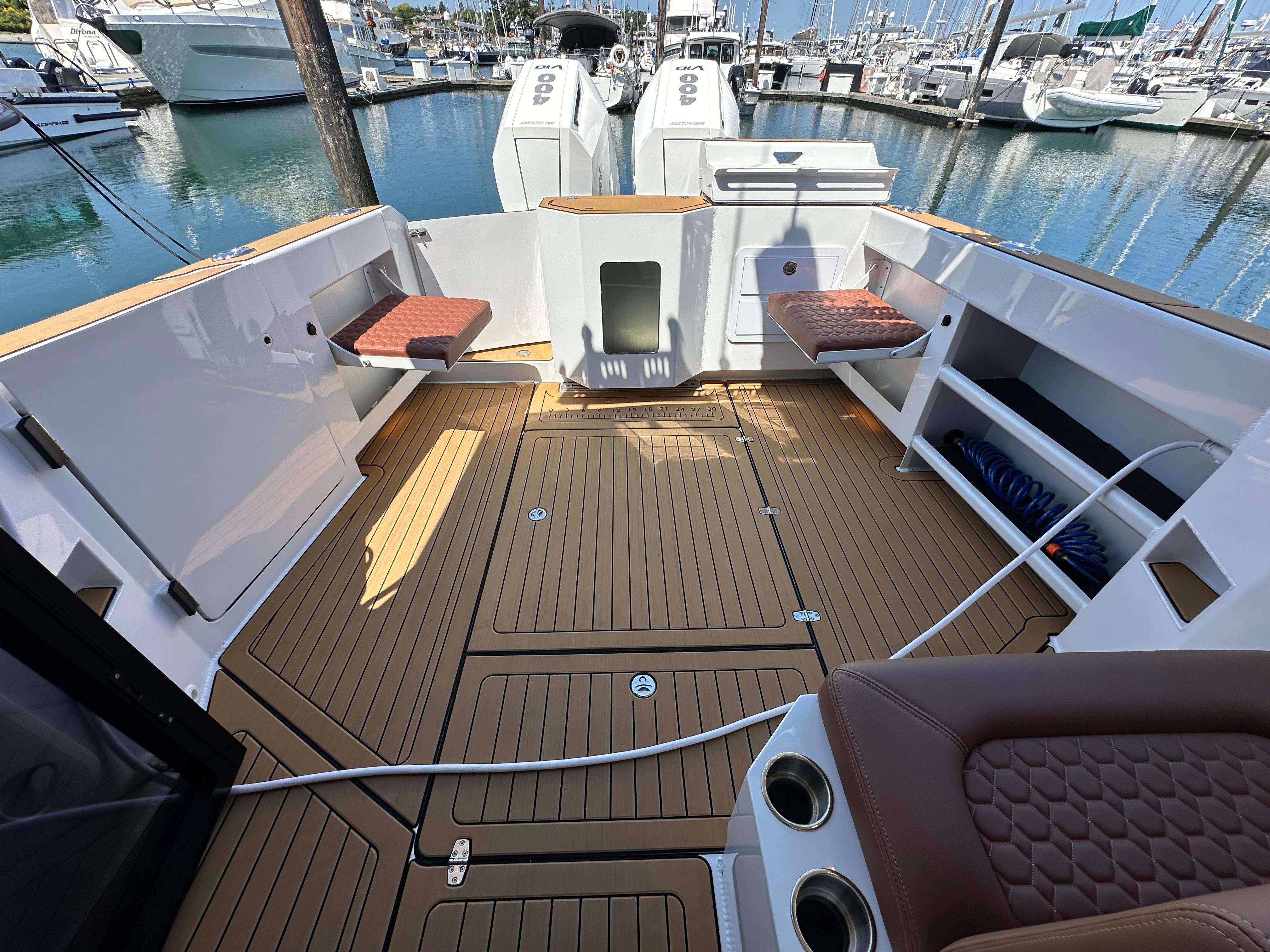 2024 Herley 11 Explorer boat deck with seating and storage, docked at marina.