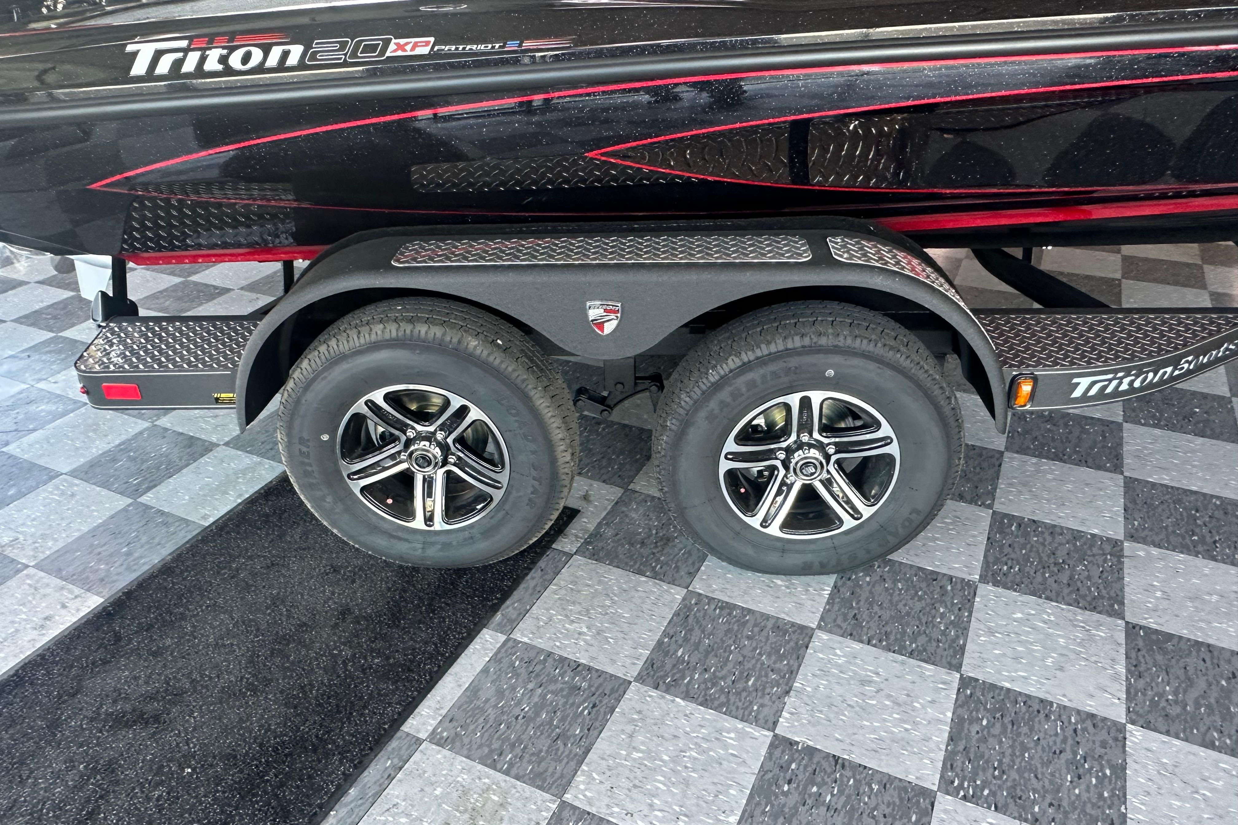 2026 Triton 20XP Patriot boat trailer with dual wheels on checkered floor.