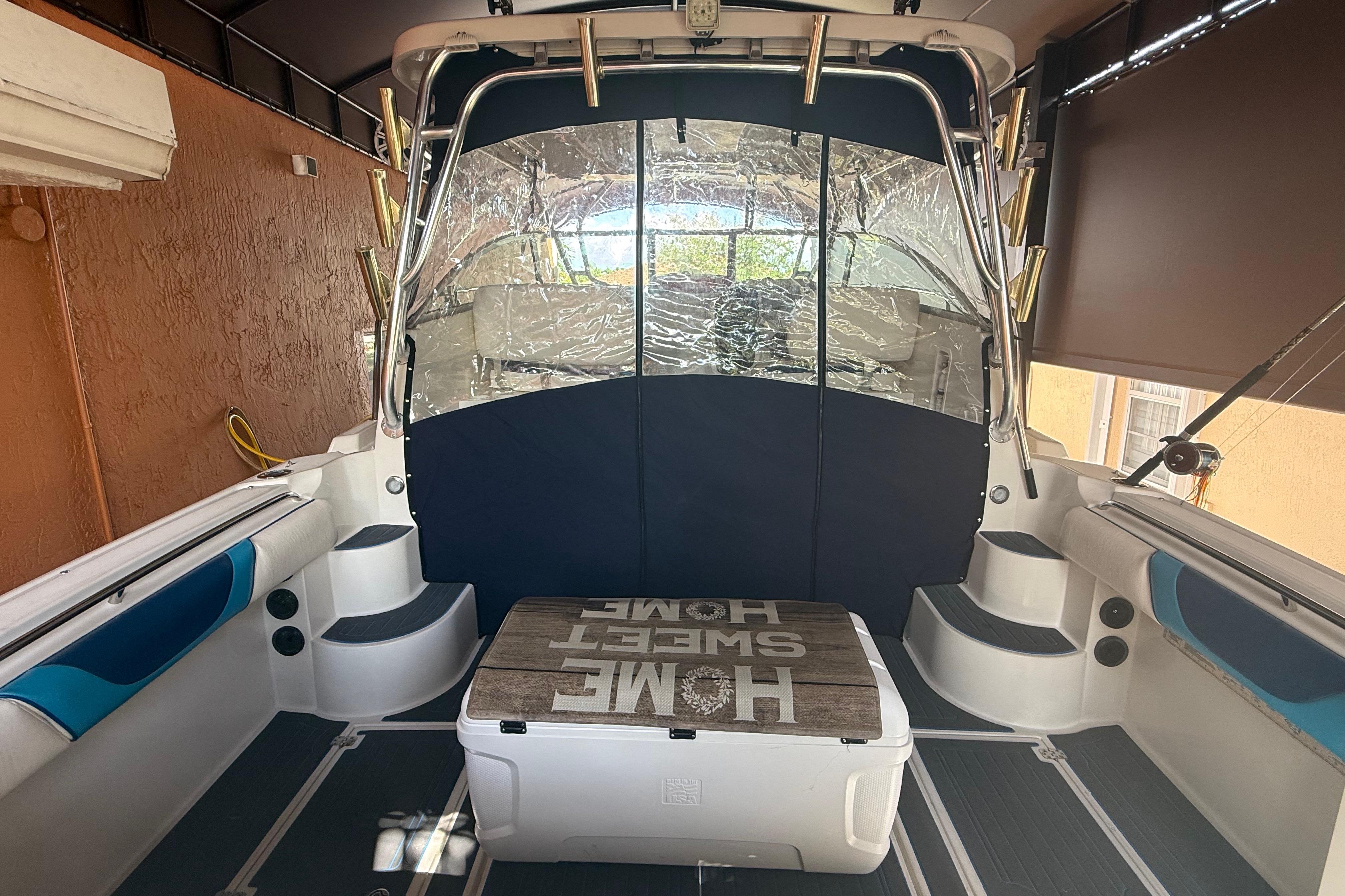 2005 Seaswirl Striper 290 boat interior with seating and cooler, docked in a covered area.