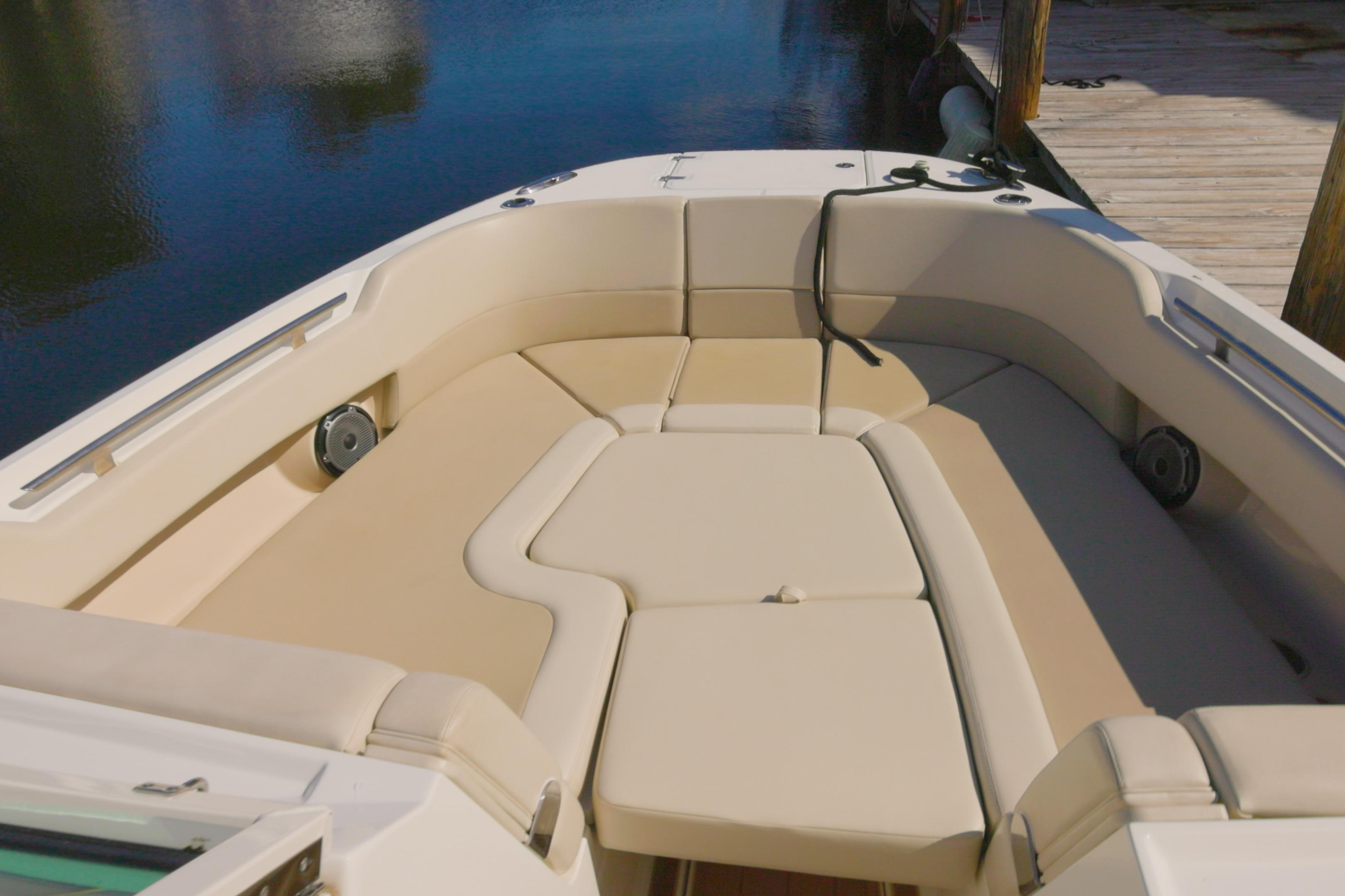 2023 Boston Whaler 320 Vantage boat interior with beige seating, docked by water.