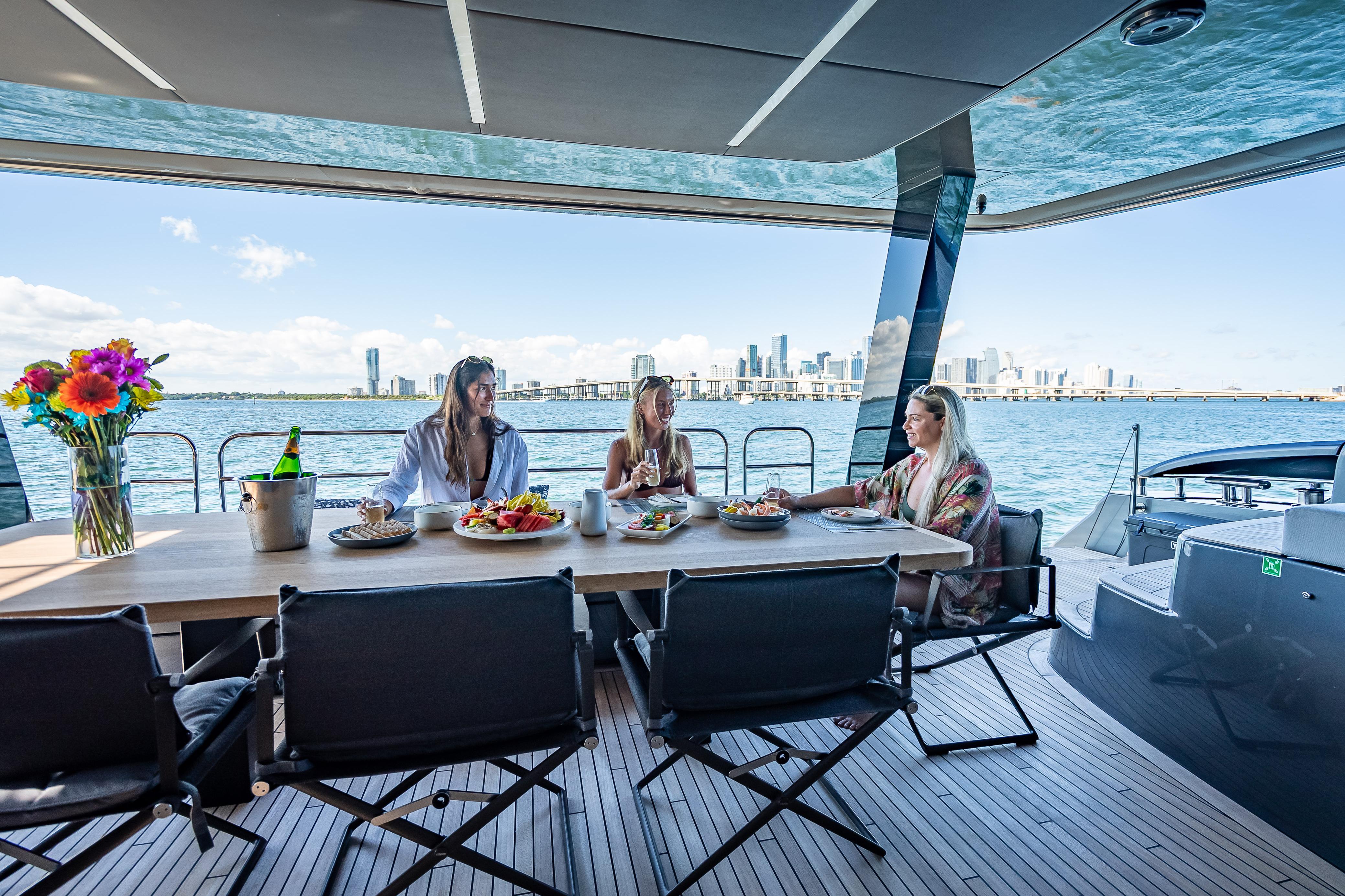 Luxury dining on 2026 Sunreef 60 Power yacht with city skyline view.