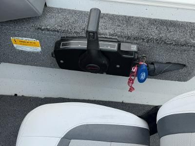 Close-up of a boat control lever with gray carpeted flooring.