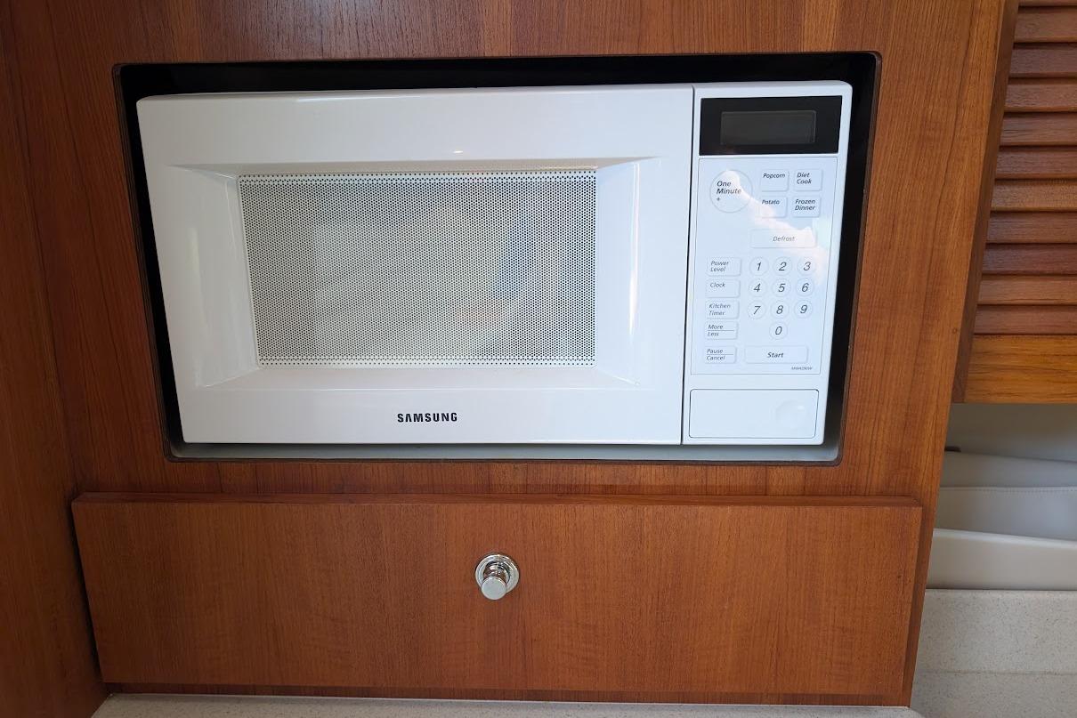 Samsung microwave in a 2000 Pursuit 3400 Express boat's wooden interior.