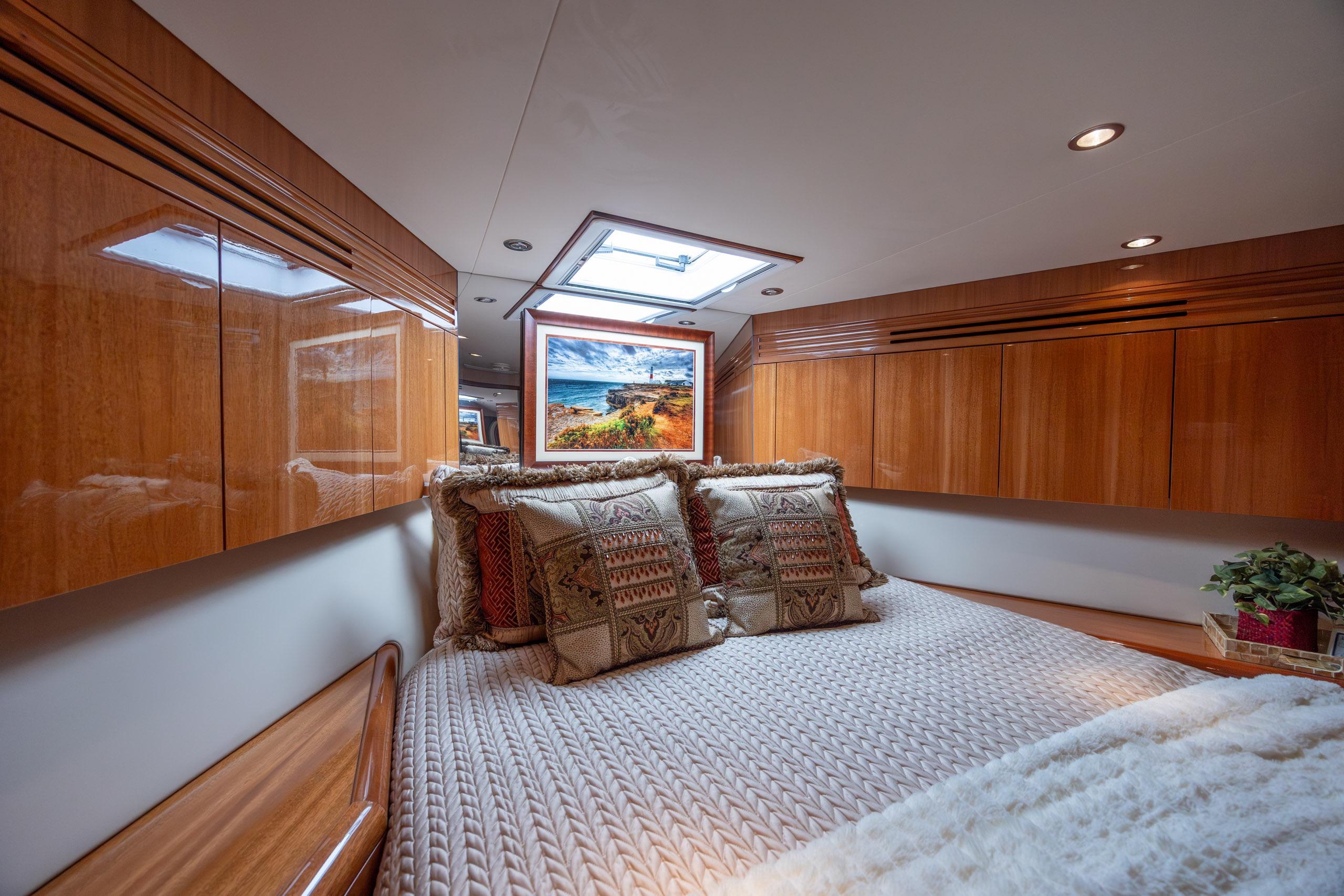 Luxurious bedroom interior of 2007 Hatteras 64 Motor Yacht with elegant wood cabinetry.
