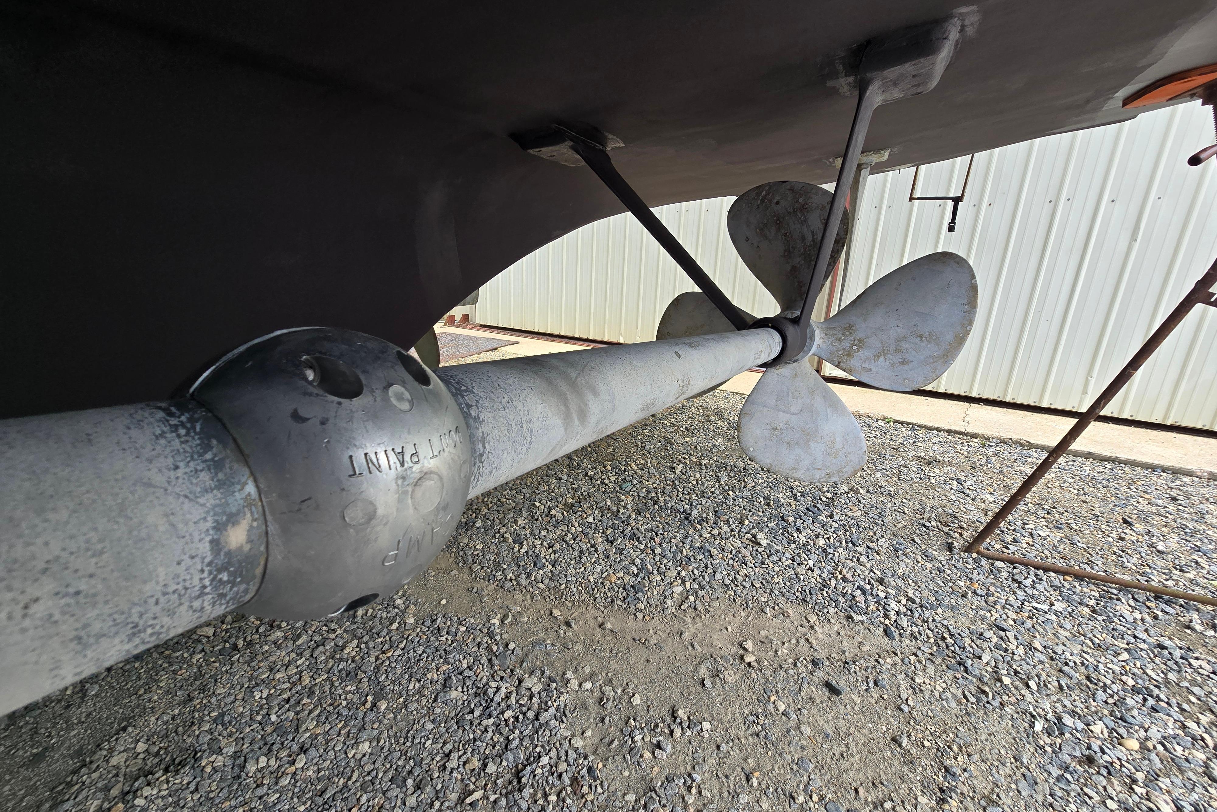 Propeller and shaft of a 1980 Hatteras 70 Motor Yacht on gravel surface.