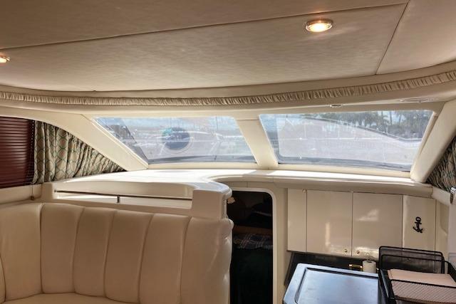 Interior of 1997 Sea Ray 370 Aft Cabin yacht with plush seating and large windows.