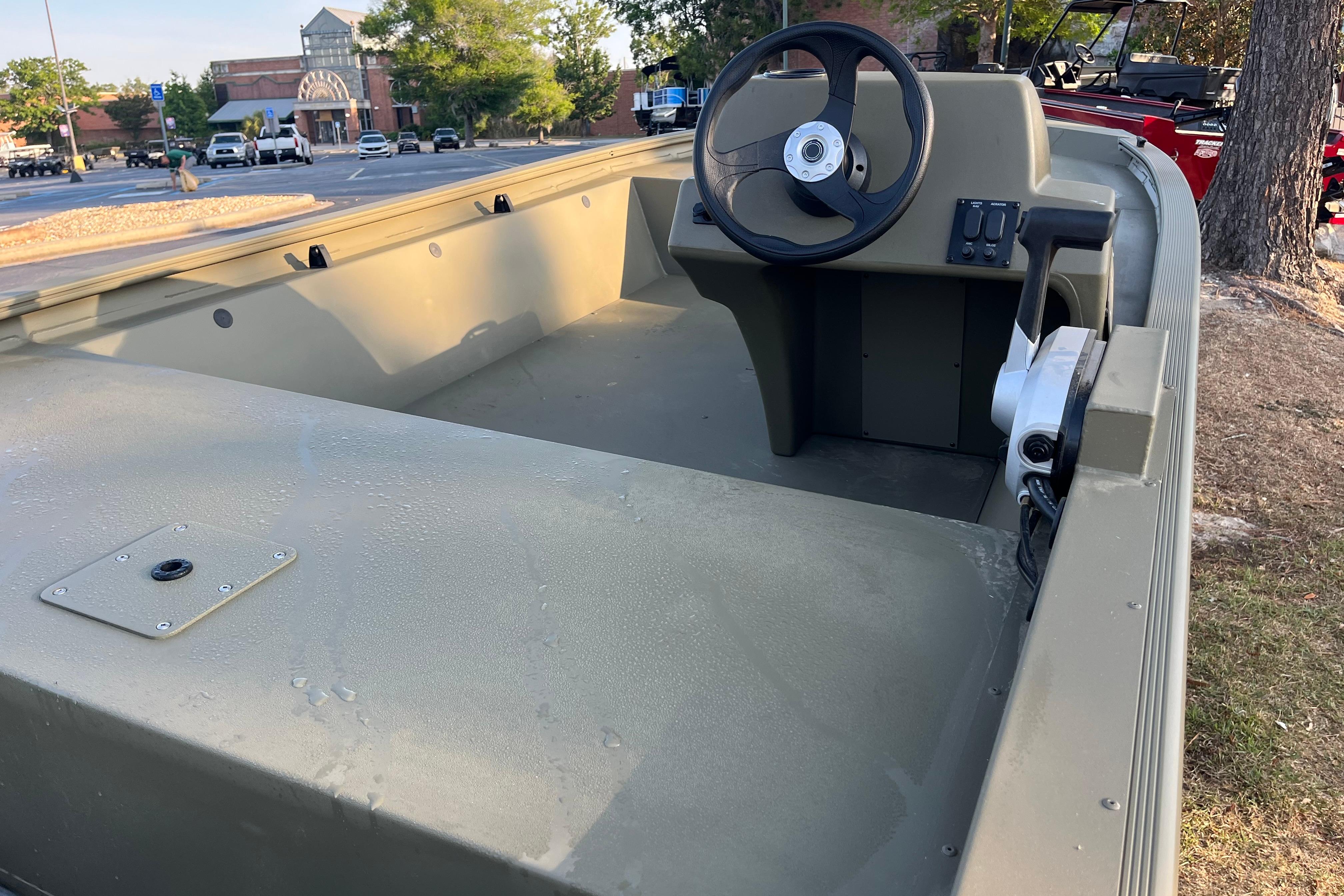 2026 Tracker Grizzly 1648 SC boat interior with steering wheel, parked outdoors.