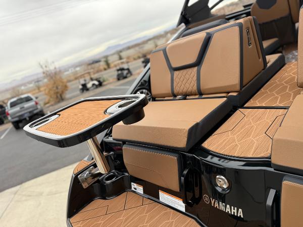 2025 Yamaha Boats 255XD interior with tan seating and a foldable table.