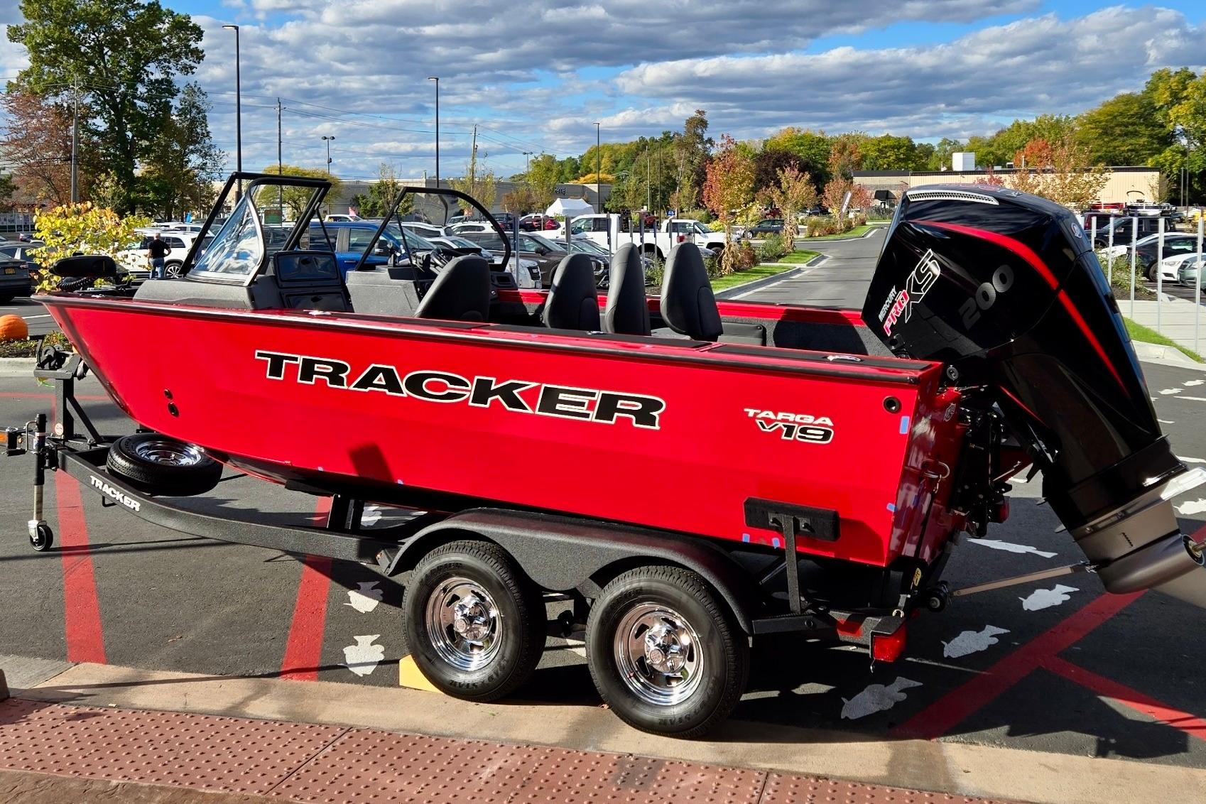 2026 Tracker Targa V-19 Combo boat, vibrant red, on trailer in parking lot.