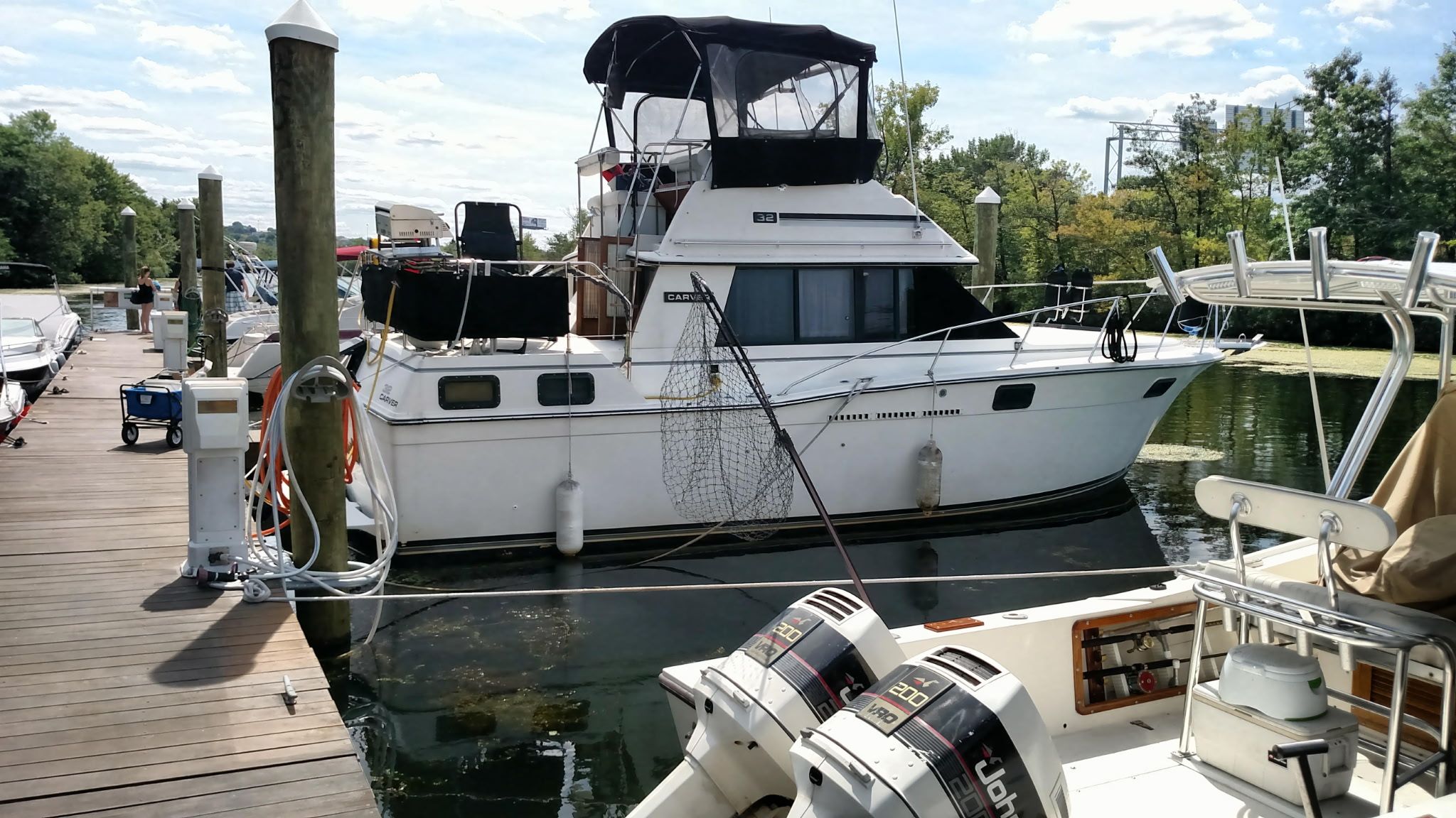 A 1985 Carver Aft Cab is docked. It features a covered upper deck.