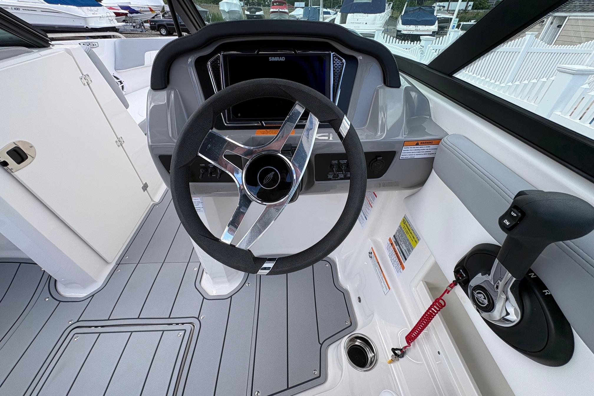 2026 Chaparral 23 SSi OB boat cockpit with steering wheel and control panel.