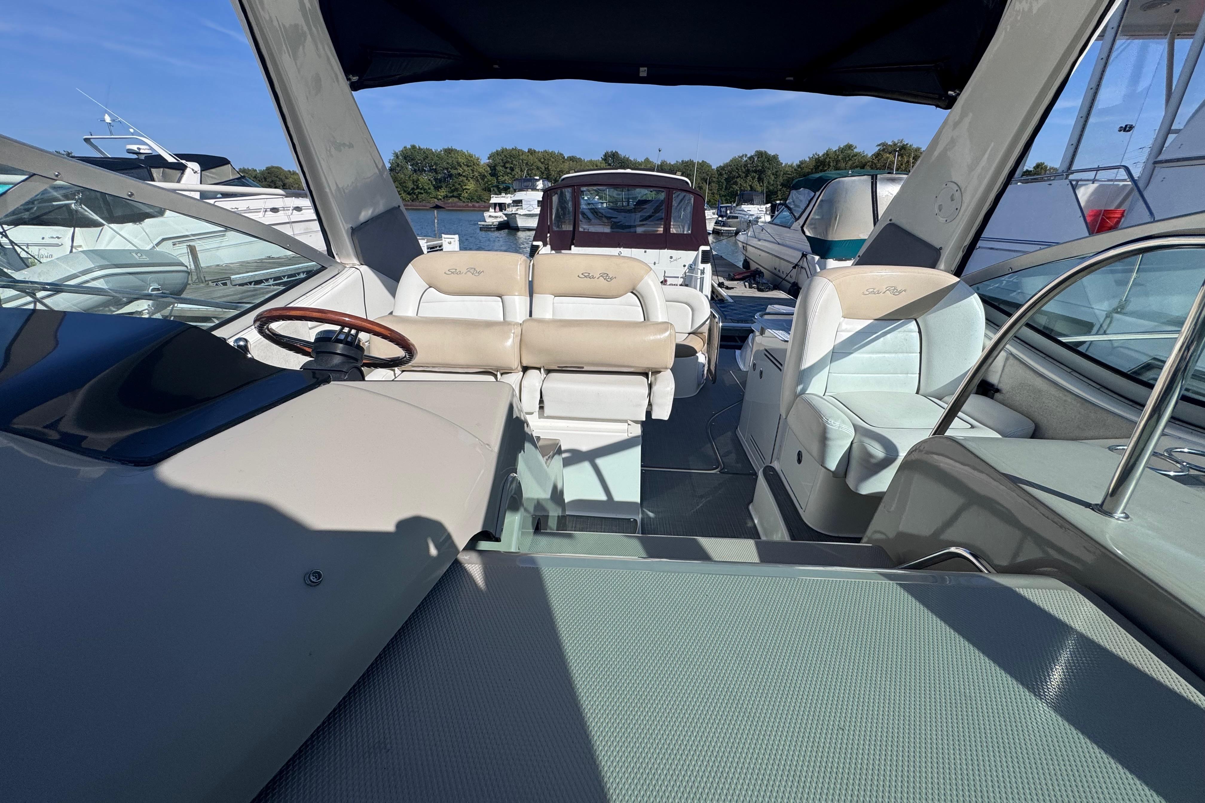 2008 Sea Ray 350 Sundancer interior with helm and seating, docked at marina.