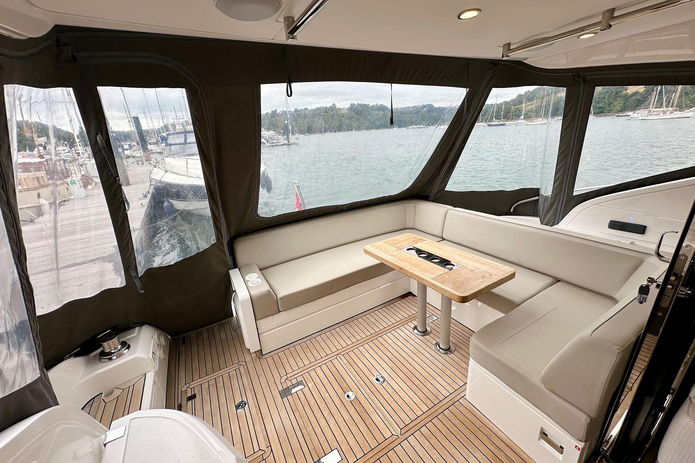 Luxurious 2022 Fairline Targa 50 GT yacht interior with elegant seating and scenic marina view.