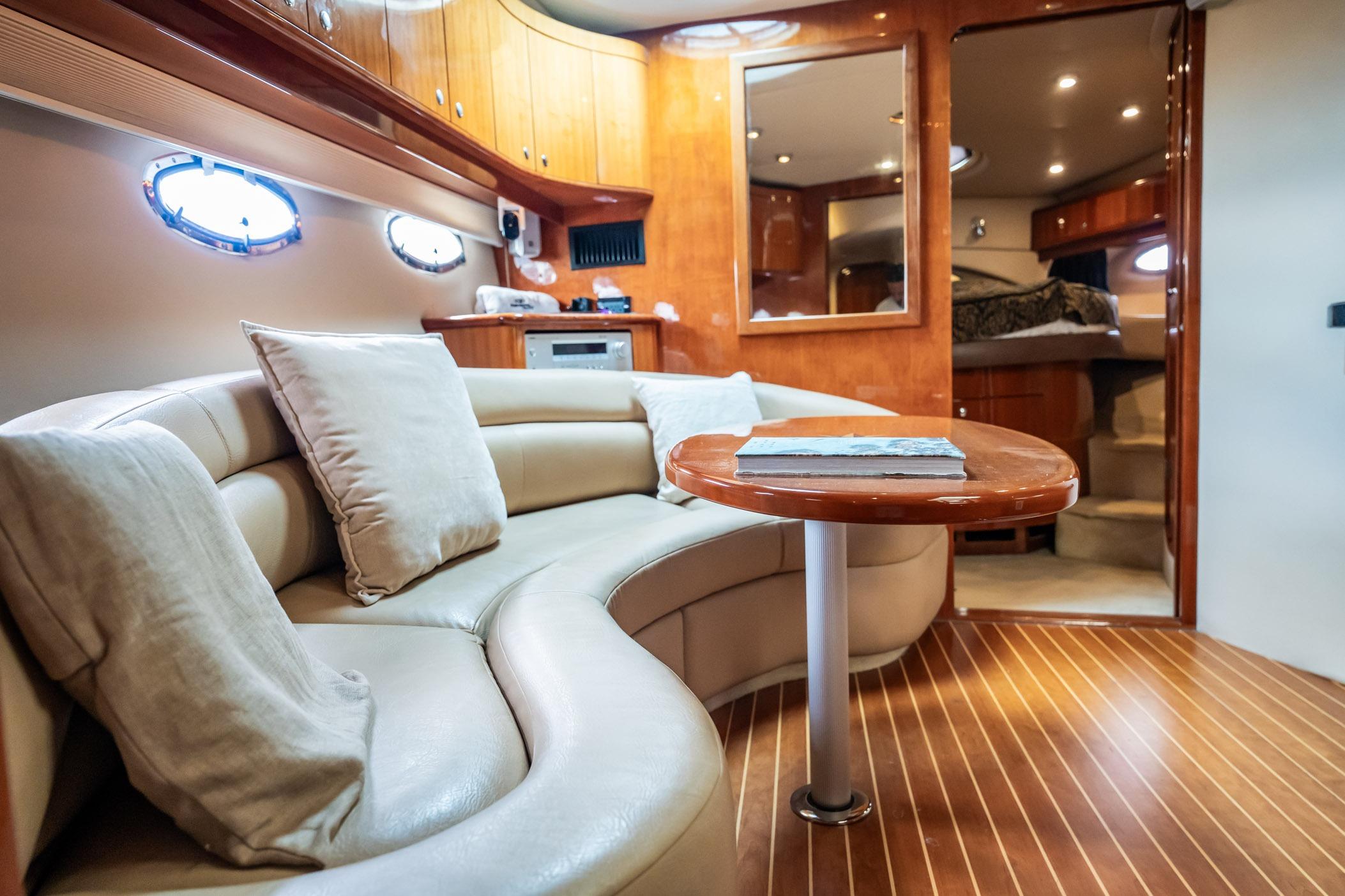 Luxurious interior of 2008 Regal Commodore 4460 yacht with plush seating and wooden accents.