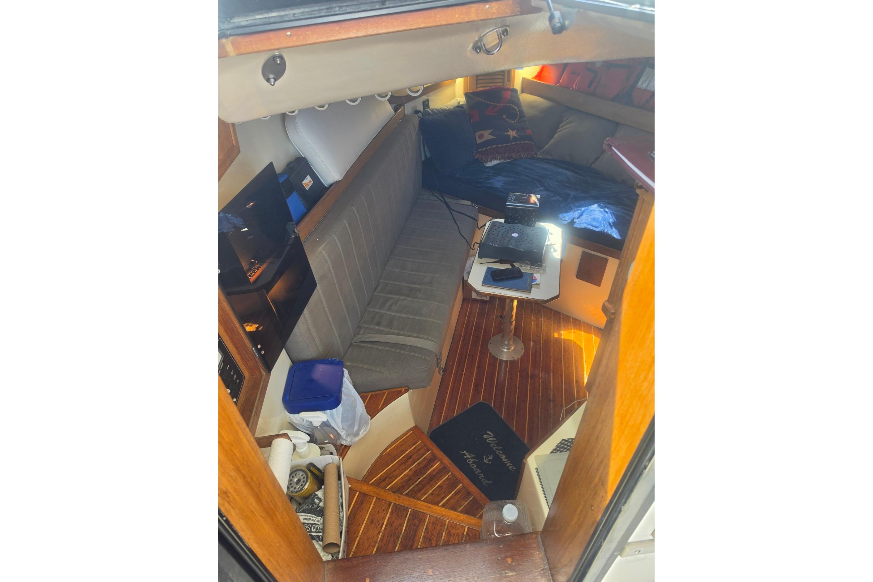 Interior of 1999 Albemarle 305 Express Fisherman boat with cozy seating and wooden flooring.
