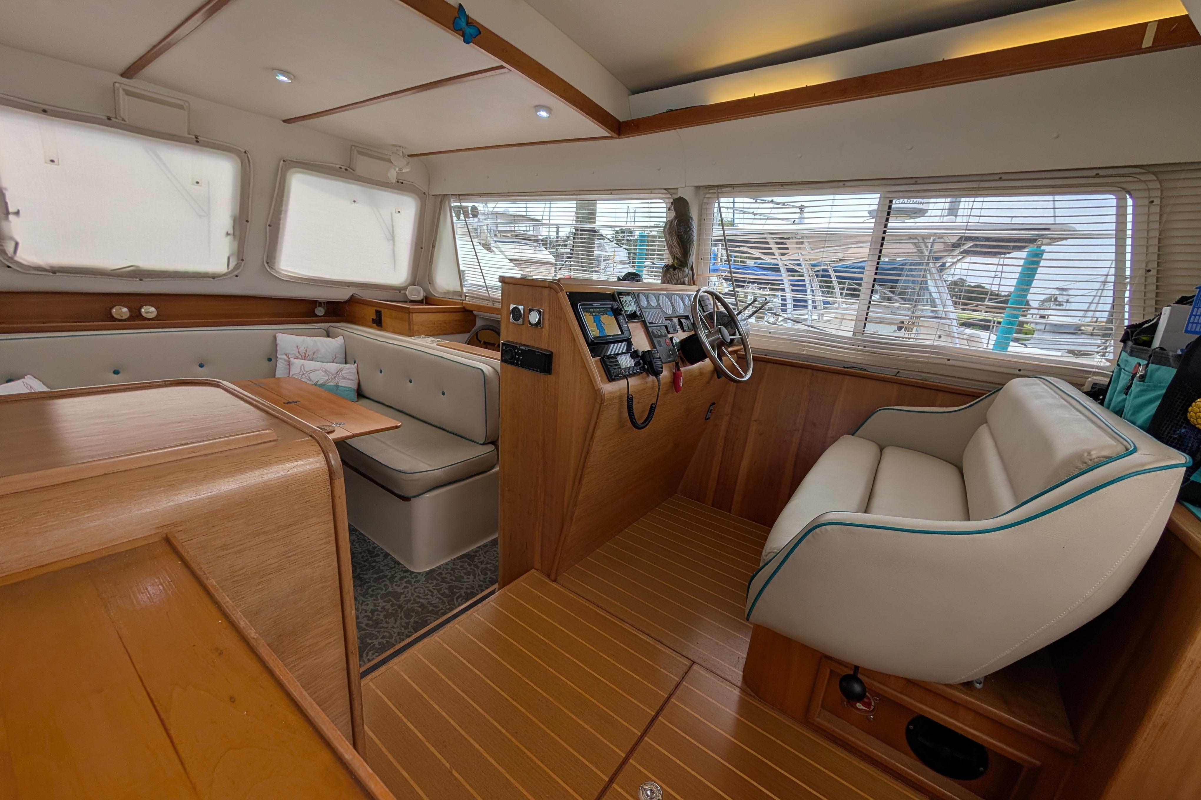Interior of a 2004 PDQ 34 Powercat, featuring a cozy seating area and helm.