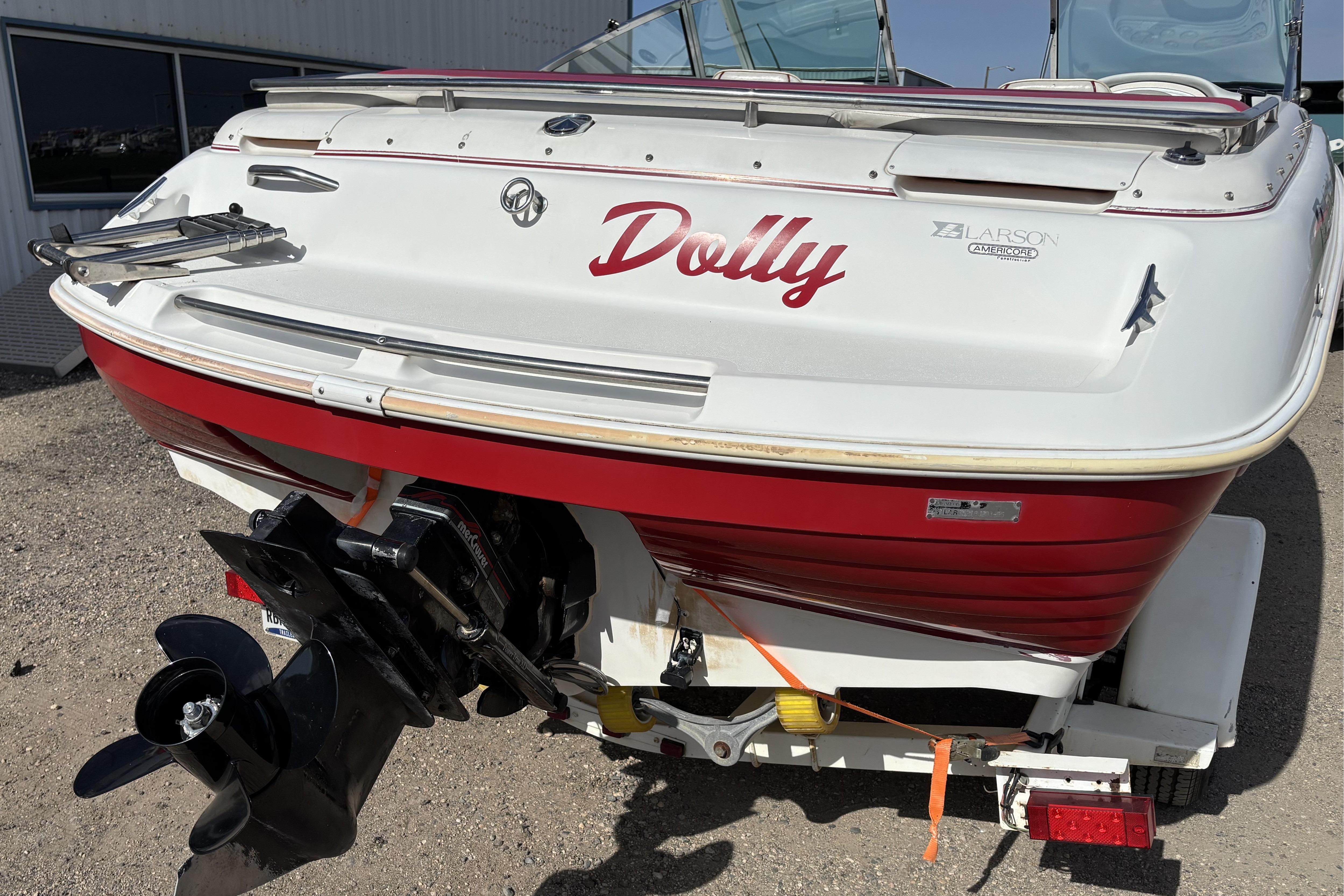 1993 Larson SEi 200 Cuddy I/O boat with red and white exterior, named "Dolly."