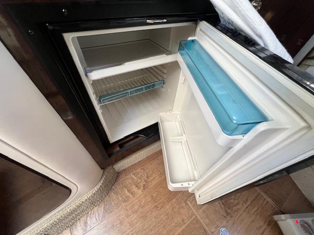 Open refrigerator inside 2017 Sea Ray 330 Sundancer boat, showing interior shelves and door storage.