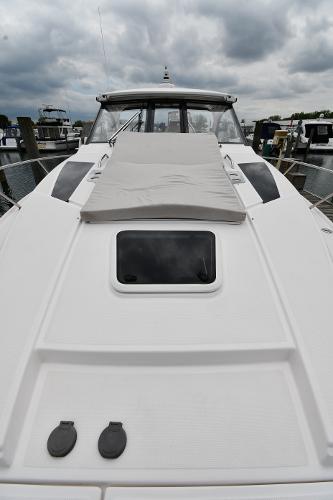 2021 Regal 35 Sport Coupe boat with sleek design, docked under cloudy skies.