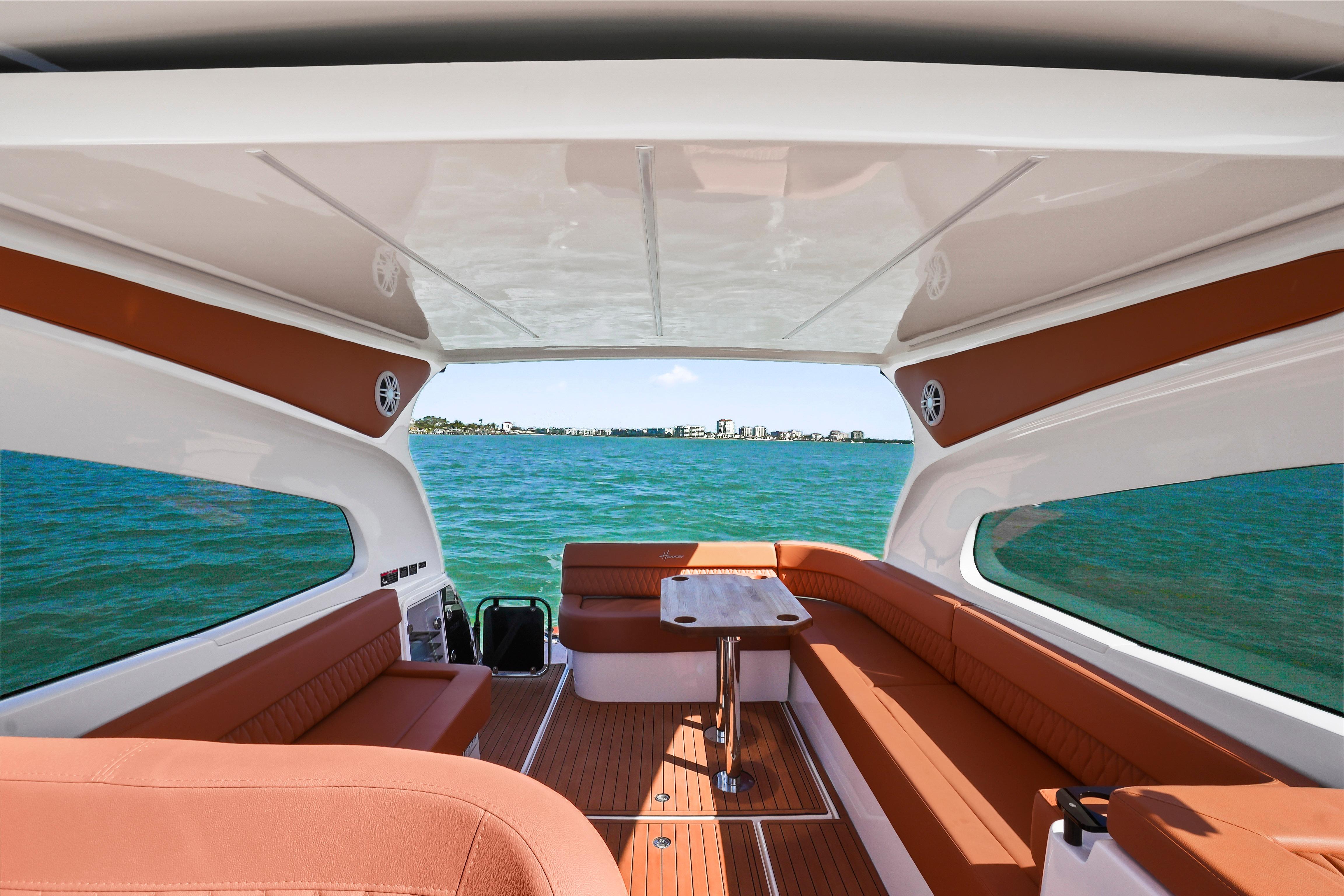 Luxurious interior of 2026 Hanover 355 boat with ocean view and elegant seating.