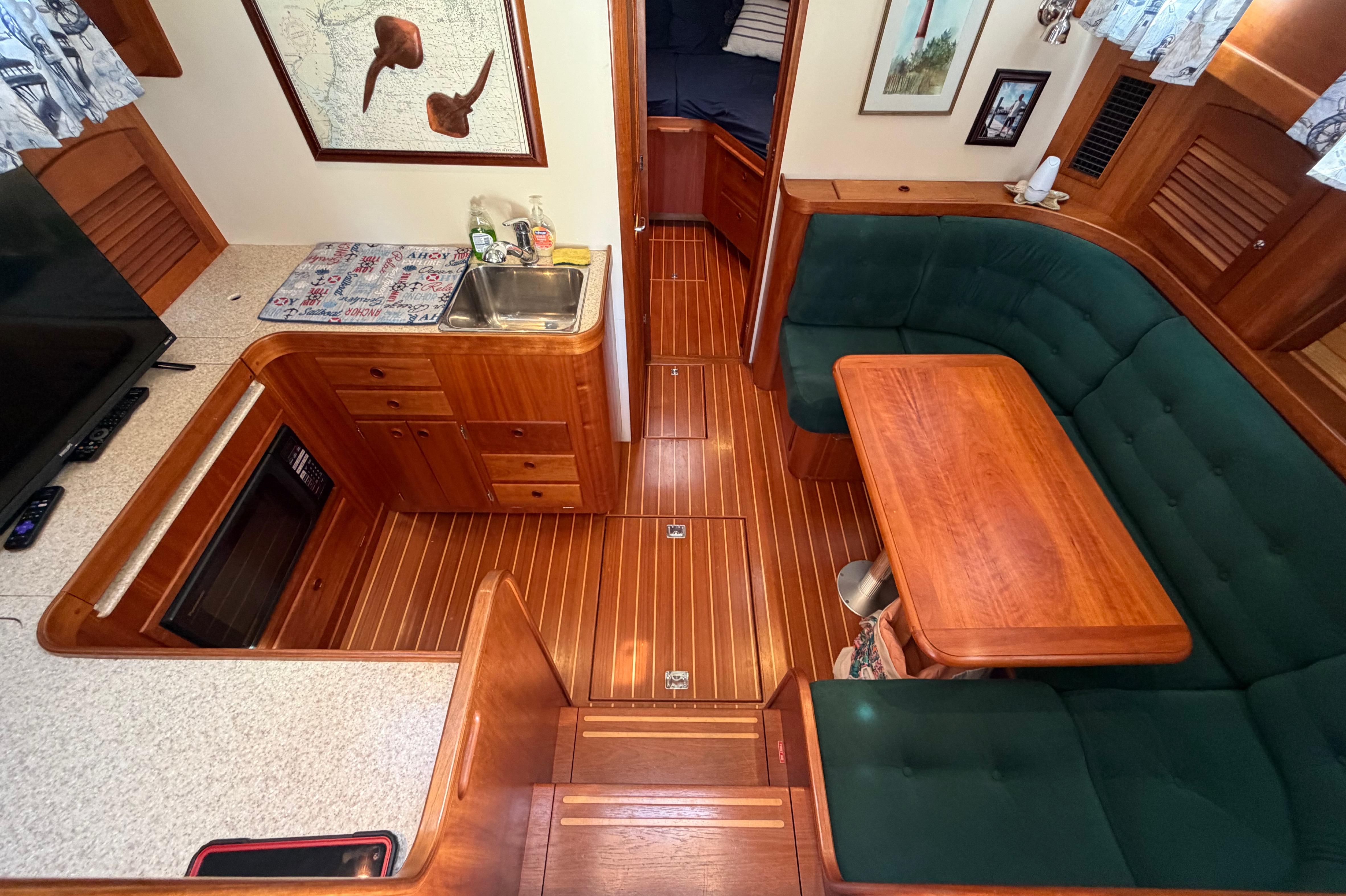 Interior of 2000 Sabreline 36 Express yacht with wood finish and green seating.