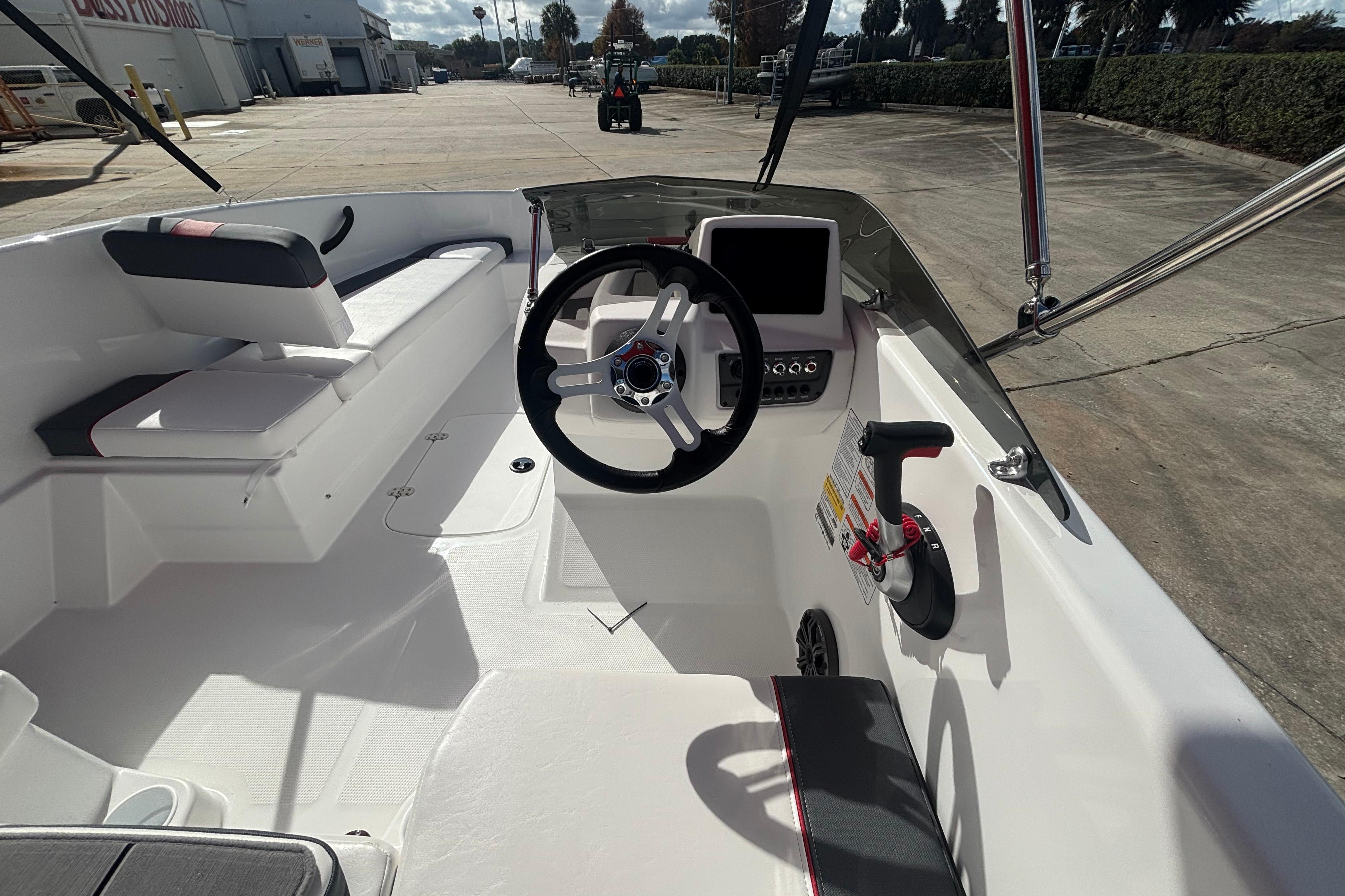 2026 Tahoe T16 boat interior with steering wheel and seating, docked outdoors.