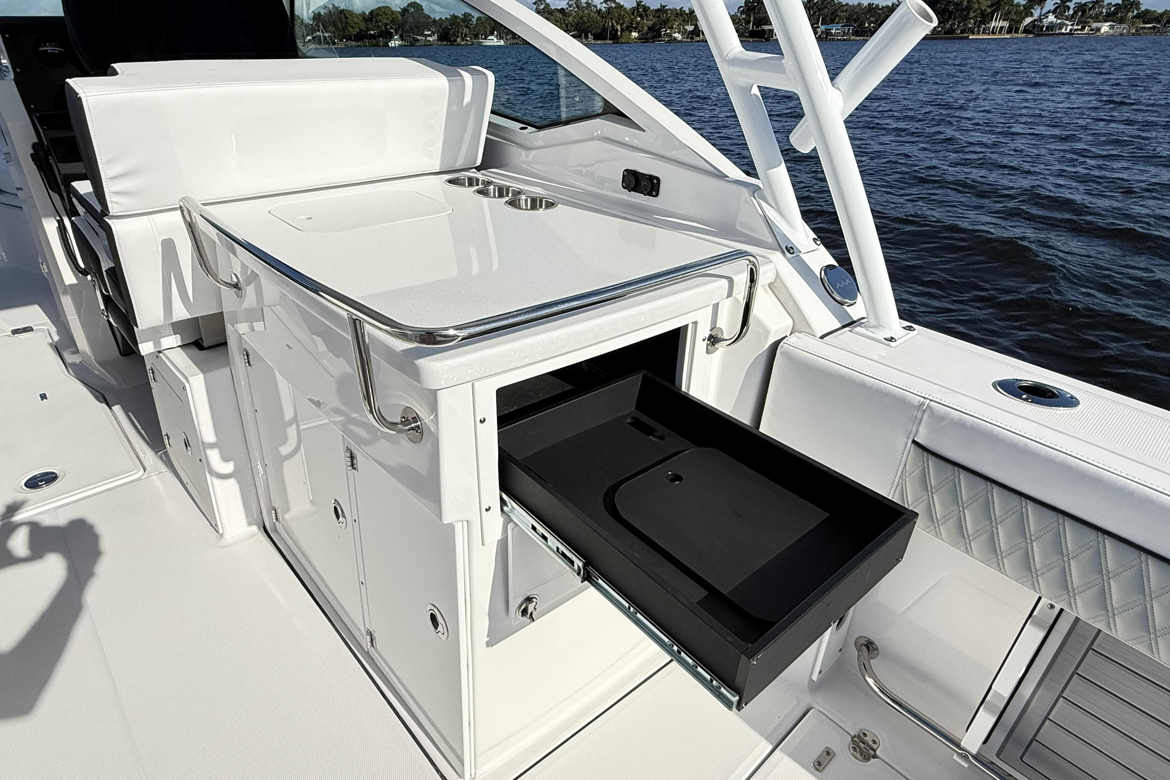 2025 Blackfin 272 DC boat interior with open storage drawer by the water.