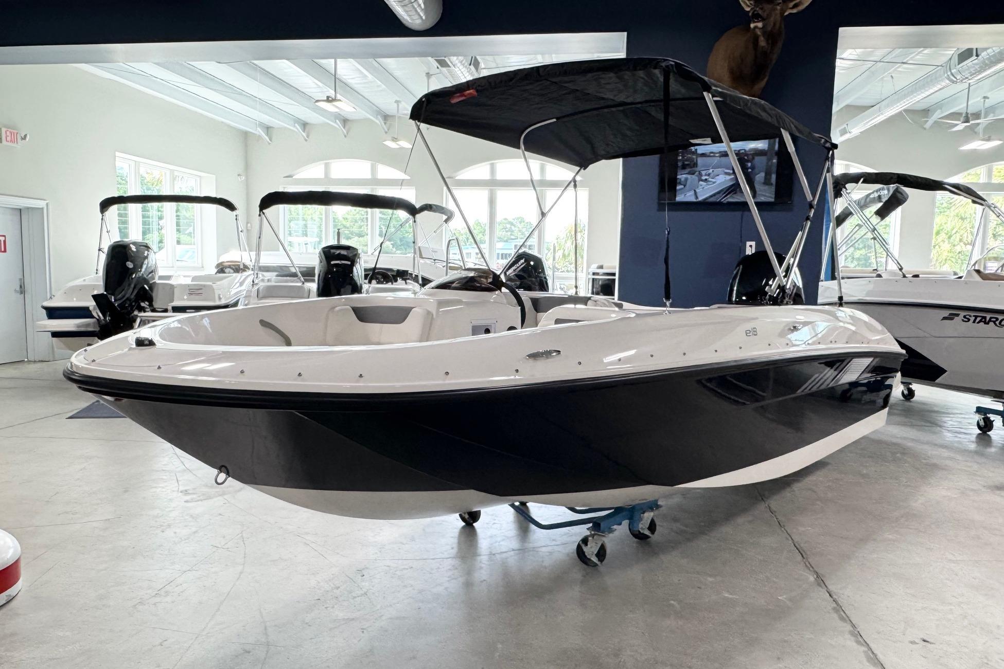 2026 Bayliner Element E18 boat displayed in a showroom with a sleek black and white design.