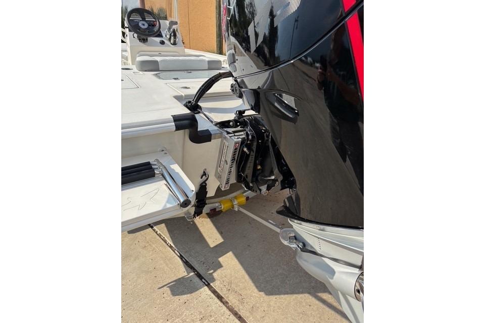 2026 Mako 18 Pro Skiff boat with outboard motor, docked on concrete surface.