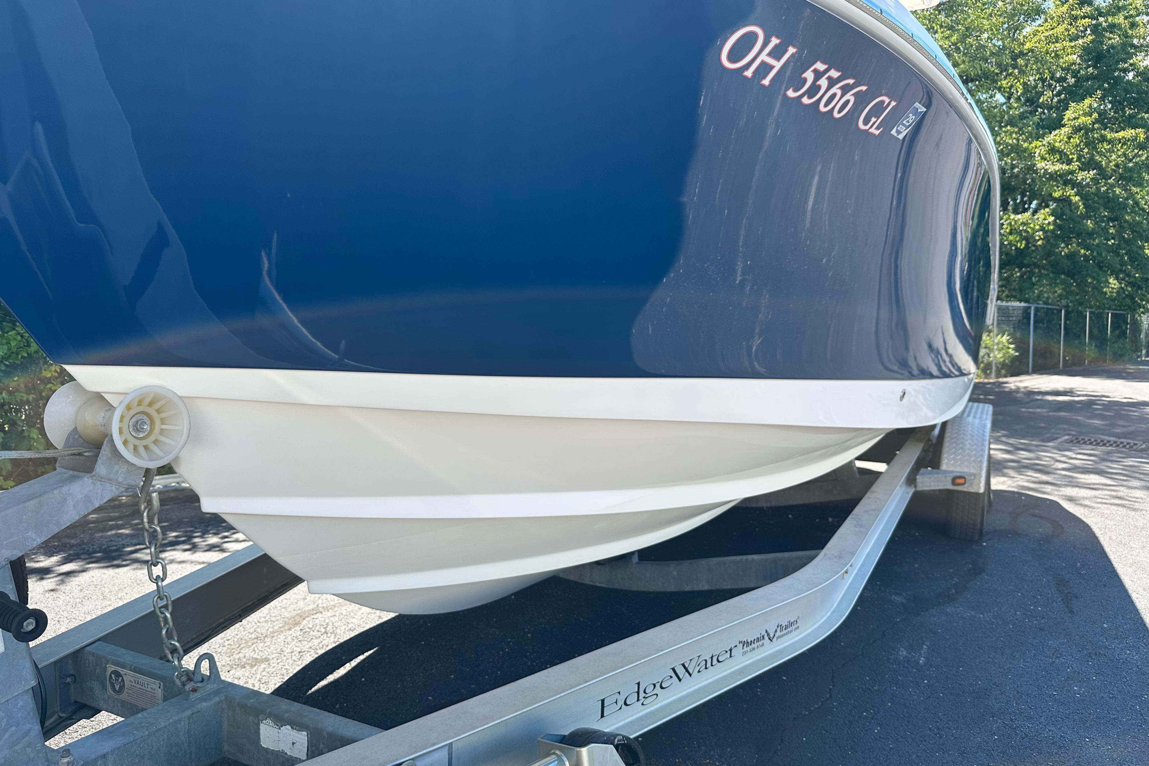 2015 Edgewater 245CC boat on trailer, blue hull, parked outdoors.