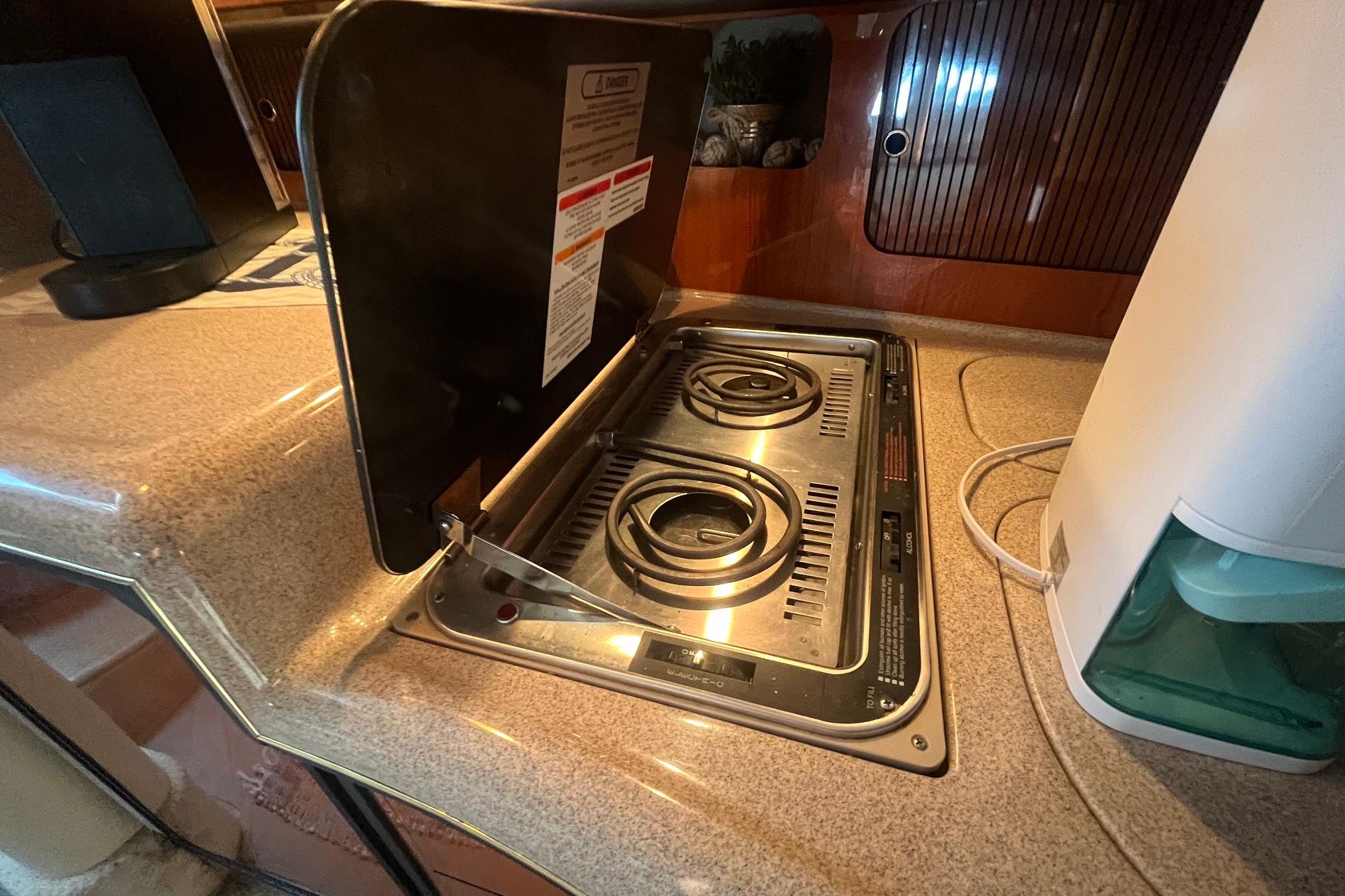 2001 Sea Ray 340 Sundancer kitchen with electric stove and countertop.