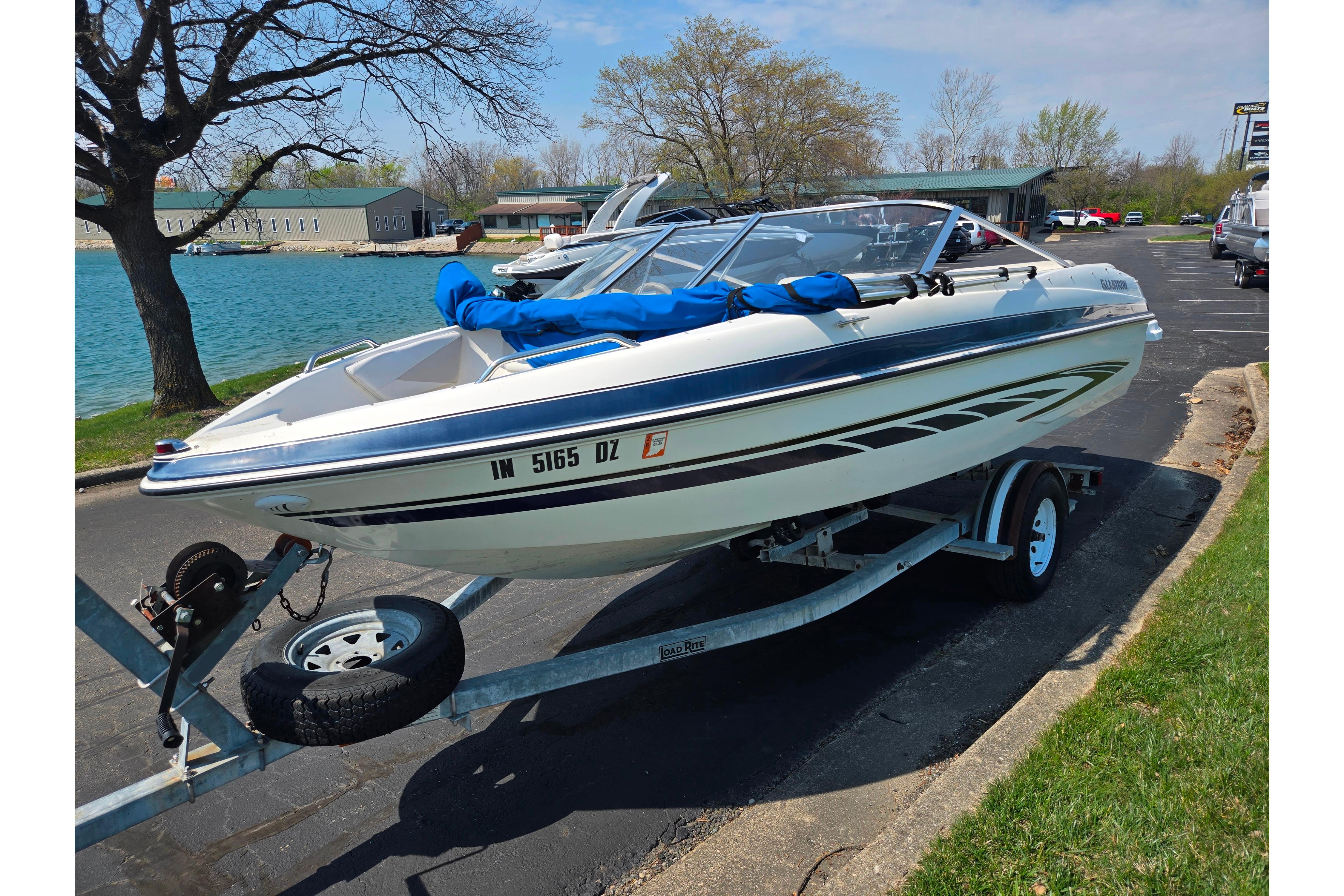 2007 Glastron GT 185 boat on trailer by lakeside, ready for adventure.