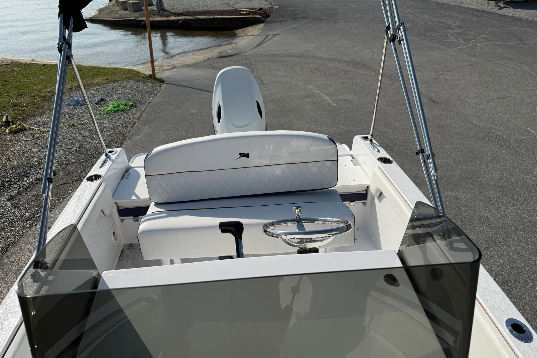 2026 Stingray 173 CC boat interior with steering wheel and seating, near water.