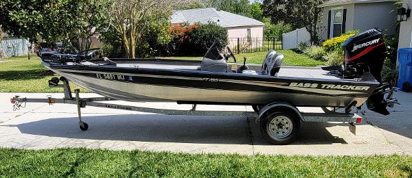 2004 Bass Tracker PRO TEAM 185 SE fishing boat on trailer in driveway.