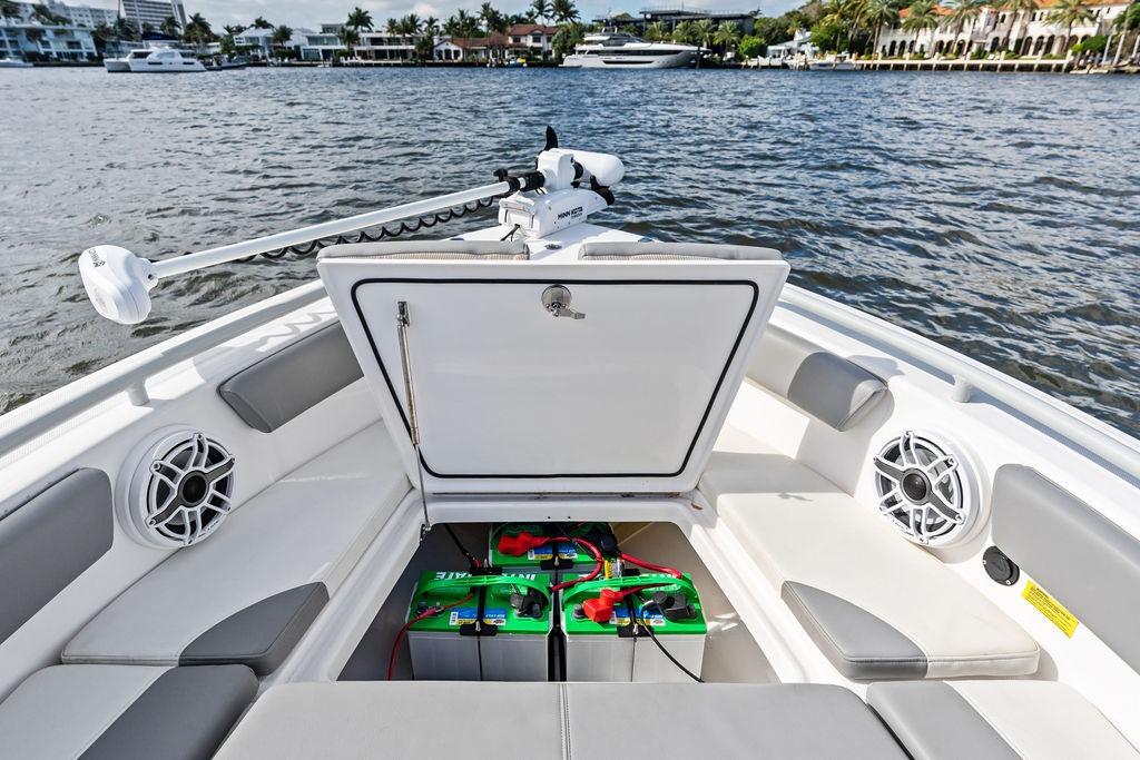 2023 Everglades 243 Center Console boat with open storage compartment and marine batteries.