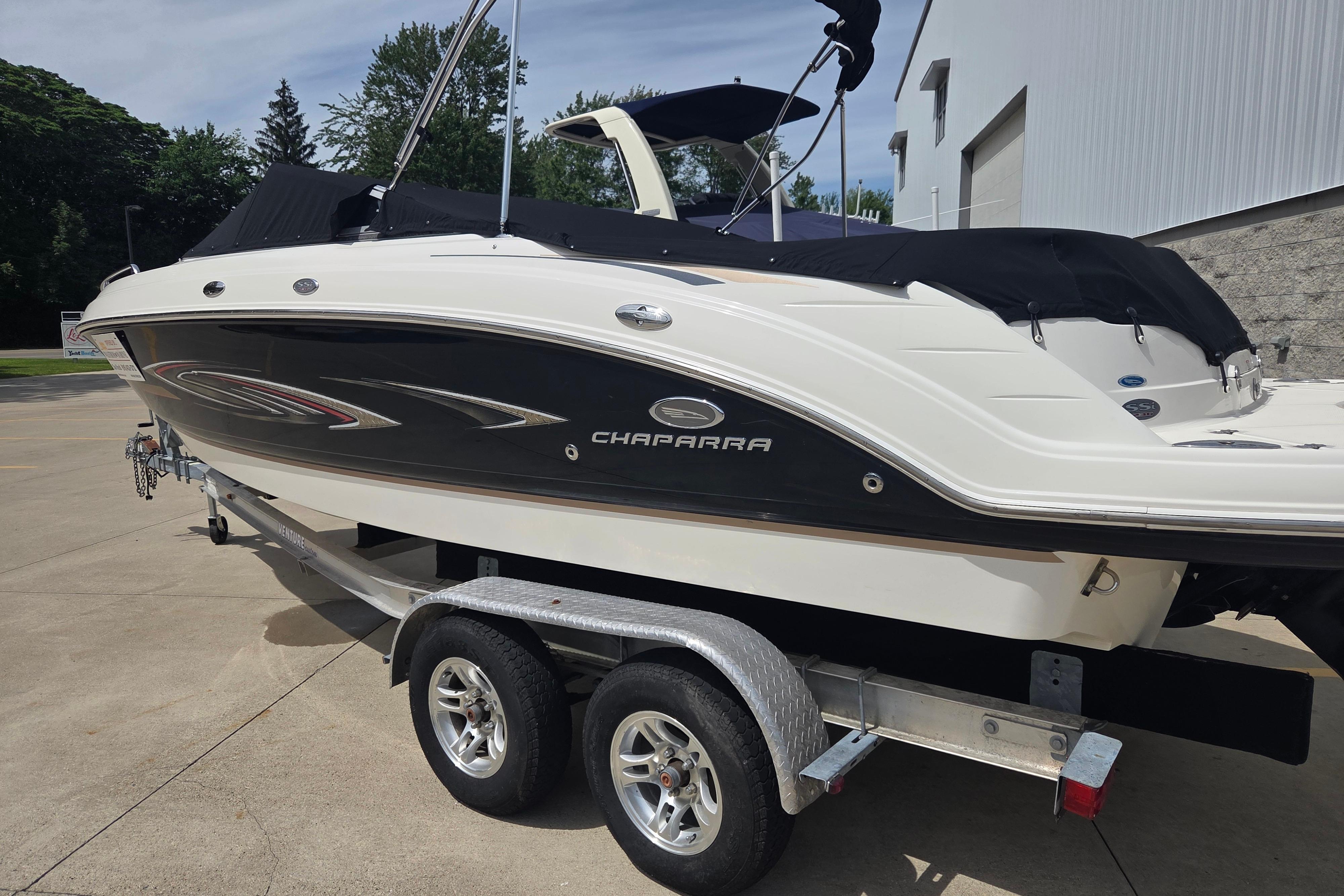 2006 Chaparral 236 SSi boat on trailer, black and white design, parked outdoors.