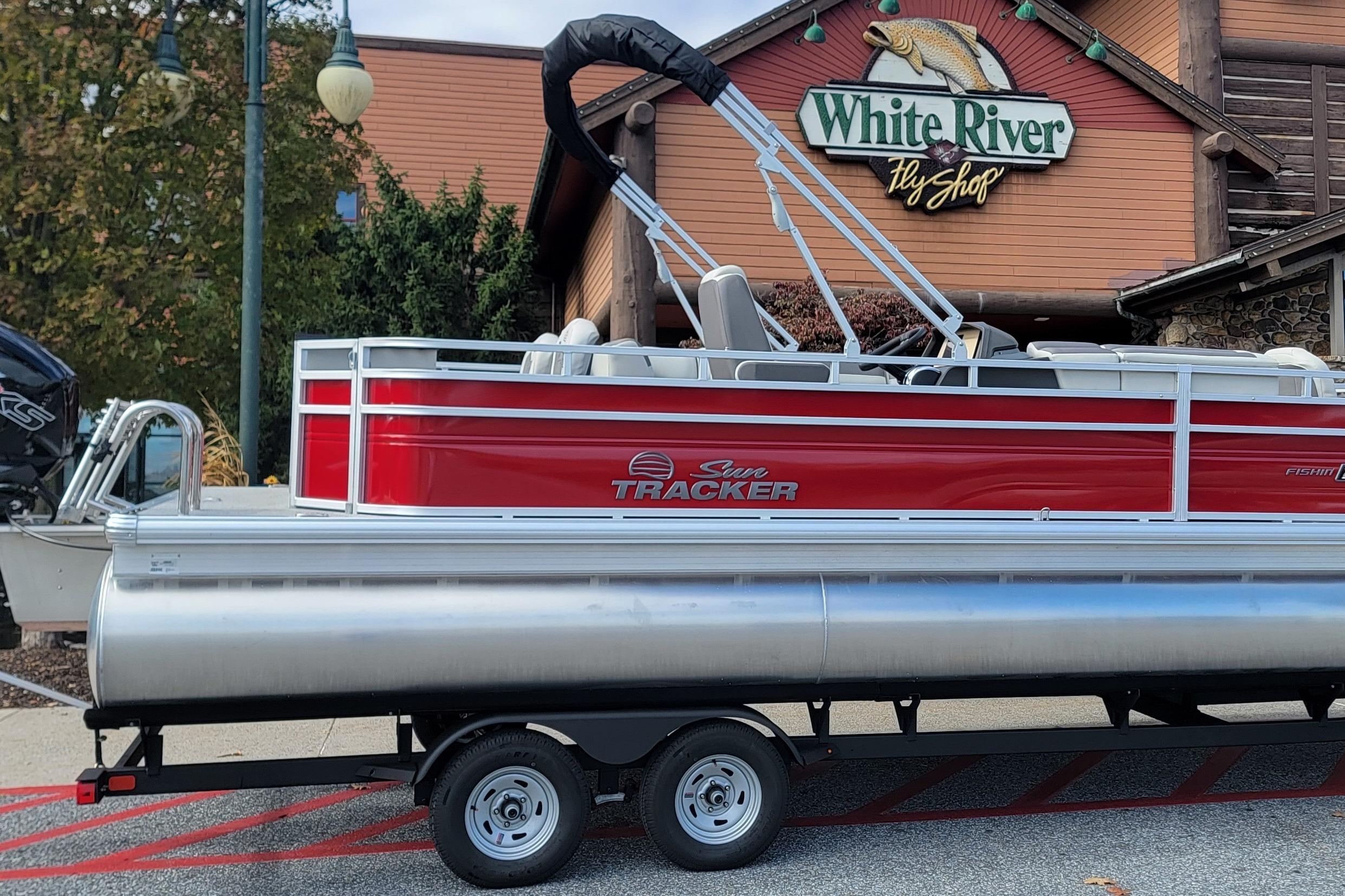 2026 Sun Tracker Fishin' Barge 22 DLX pontoon boat outside White River Fly Shop.