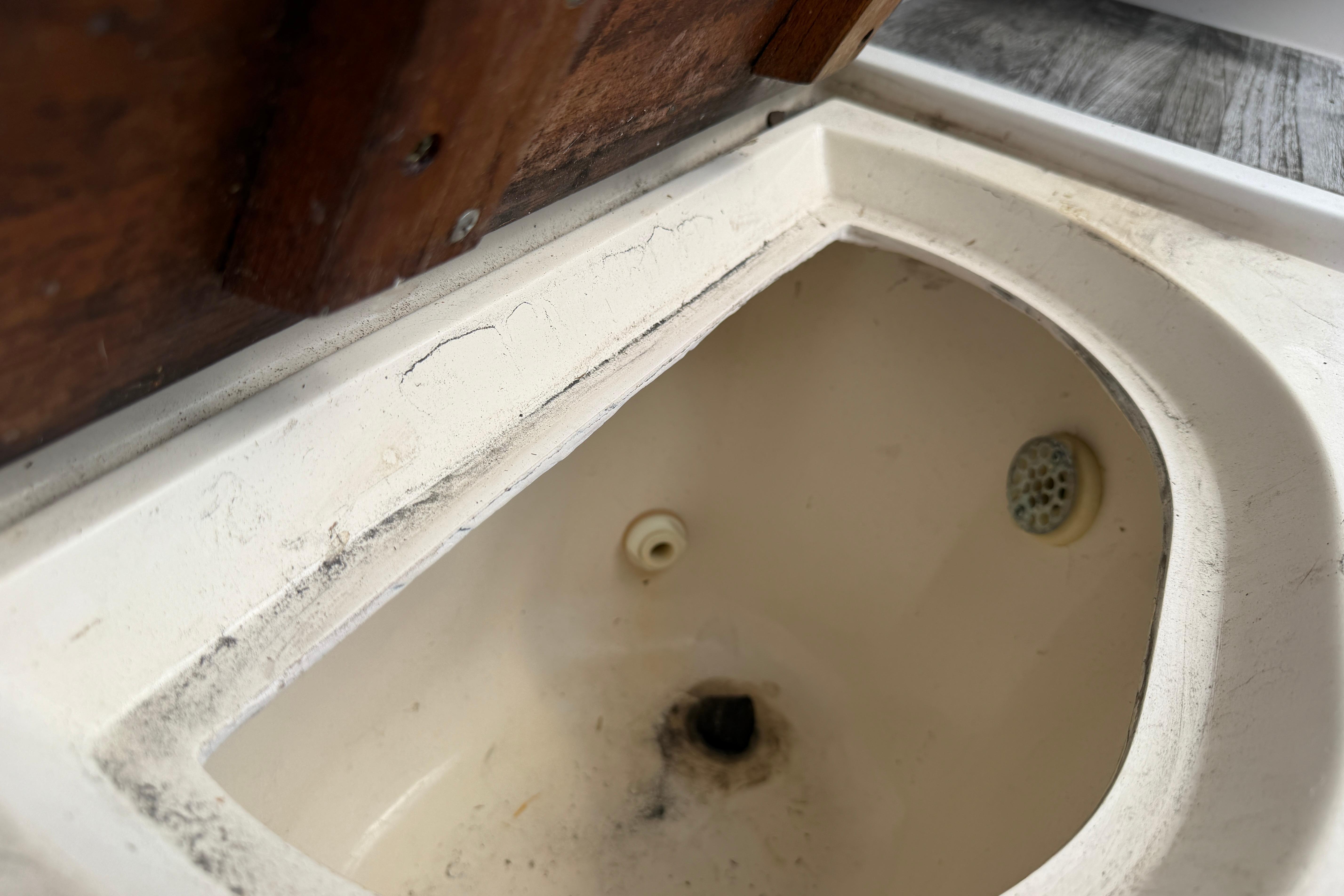 1987 Grady-White Seafarer 226 boat sink with visible wear and drain.