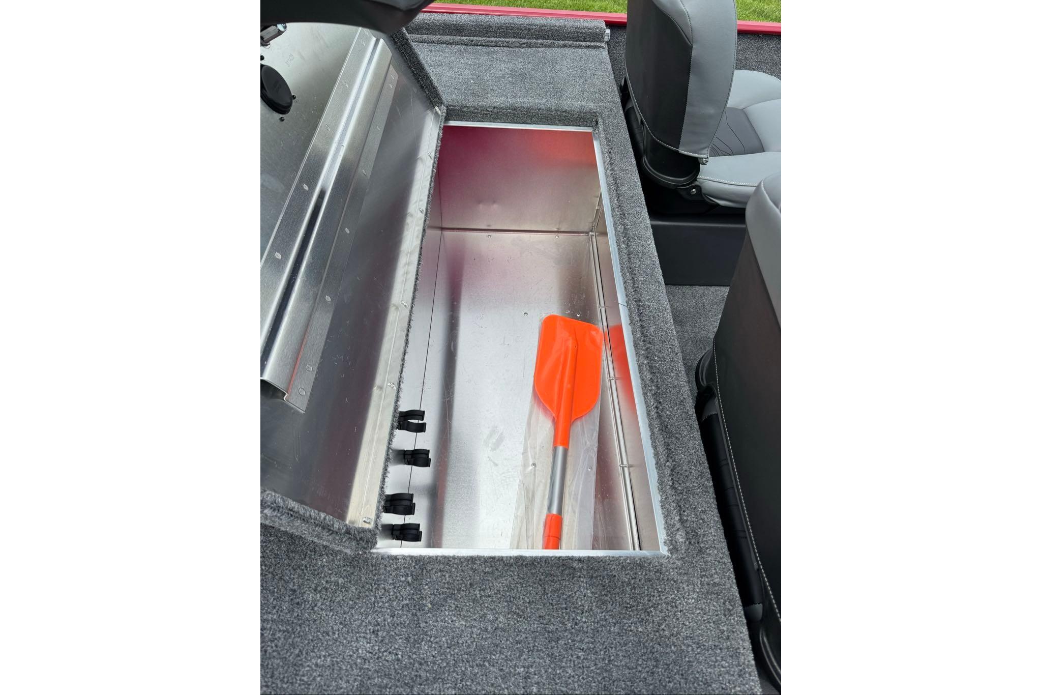 Storage compartment in 2026 Tracker Bass Tracker Classic XL boat with orange paddle.